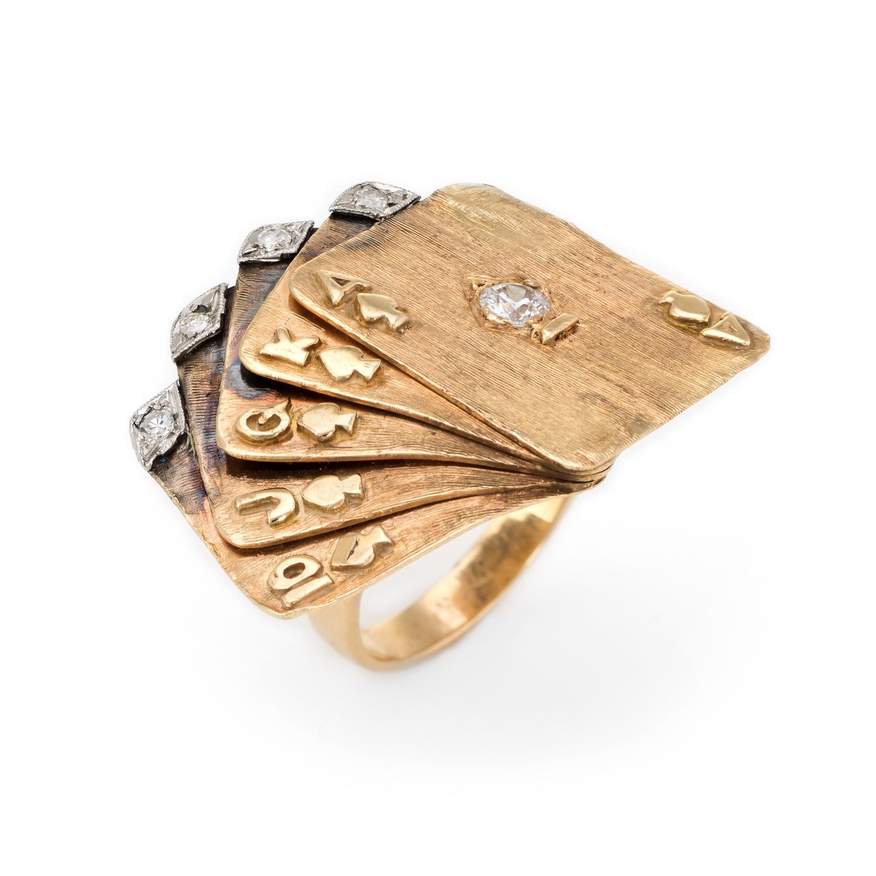 Distinct and unusual cocktail ring featuring a deck of cards (royal flush), circa 1960s to 1970s, crafted in 14 karat yellow gold. 

A larger estimated 0.20 carat old European cut diamond is set into the Ace, with four estimated 0.02 carat single