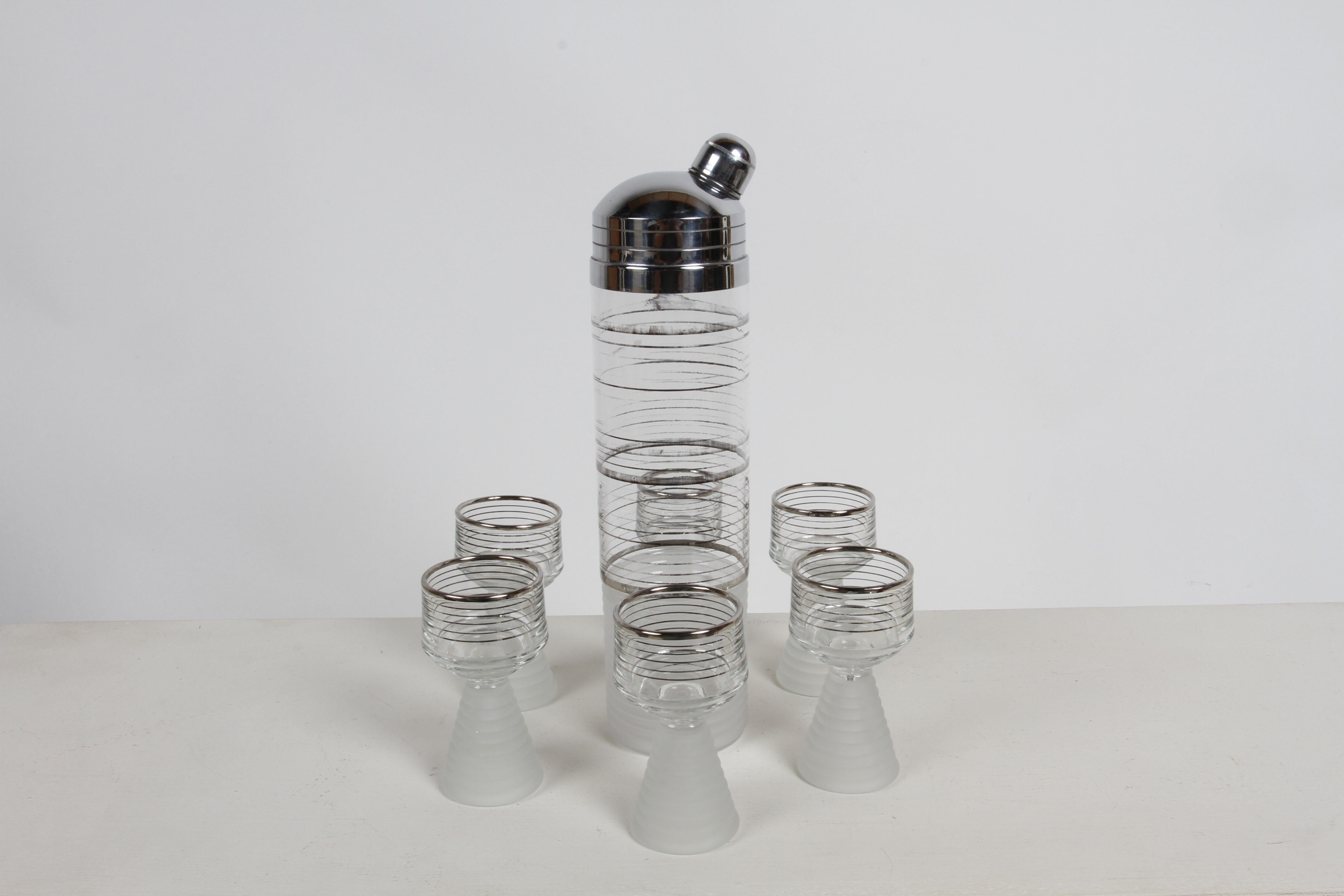 Bel set di shaker da cocktail in vetro smerigliato e strisce d'argento Skyscraper Art Deco degli anni '30 con 6 bicchieri abbinati. I bicchieri da bibita hanno basi coniche smerigliate ad anelli concentrici con  strisce argentate abbinate. Forse da
