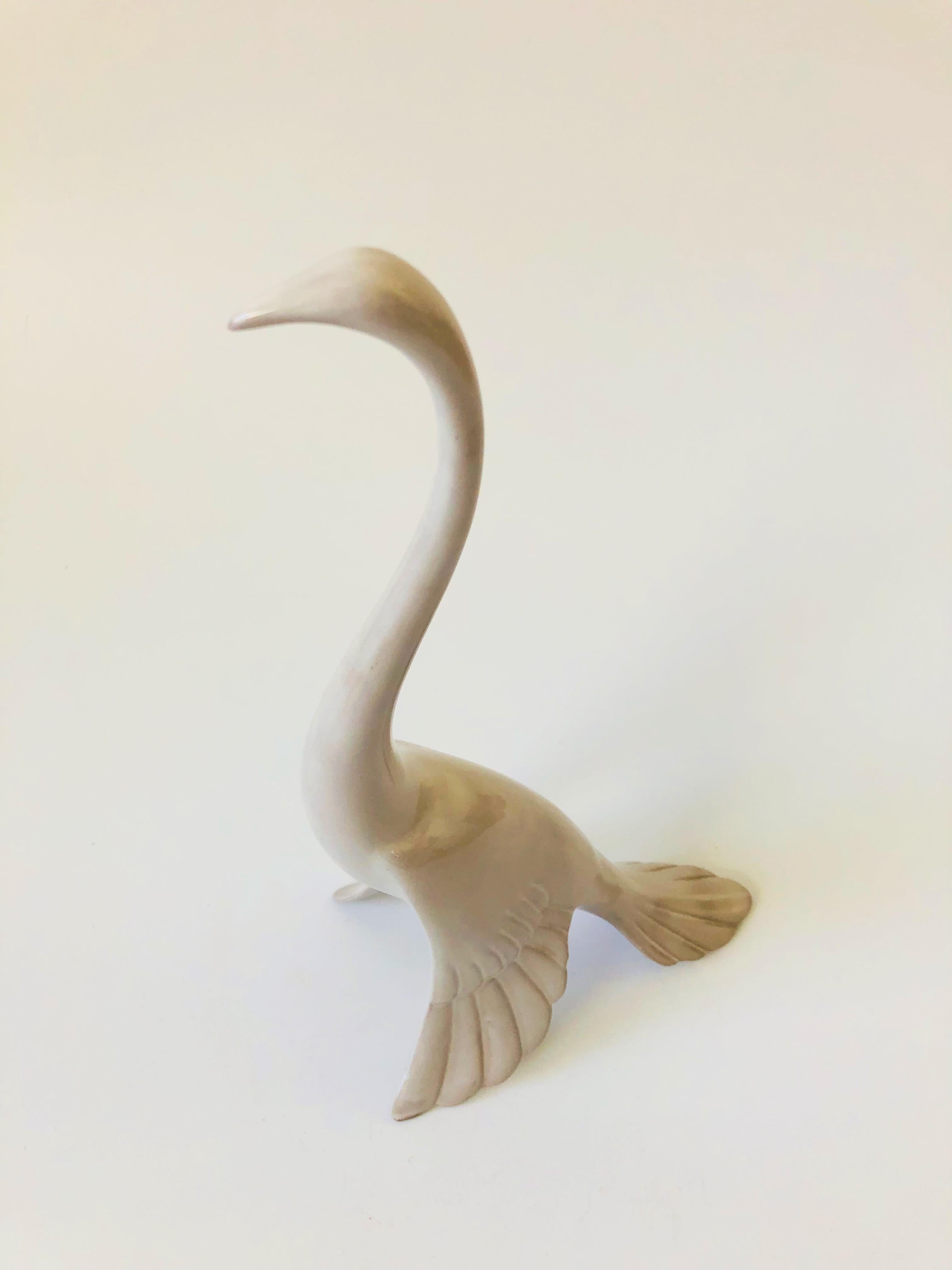 A beautiful tall mid-century art pottery crane statue. Beautiful curvy deco stylized form with a glossy white finish to the ceramic. Marked on the base, made in the USA by Anthony Freeman McFarlin.
 