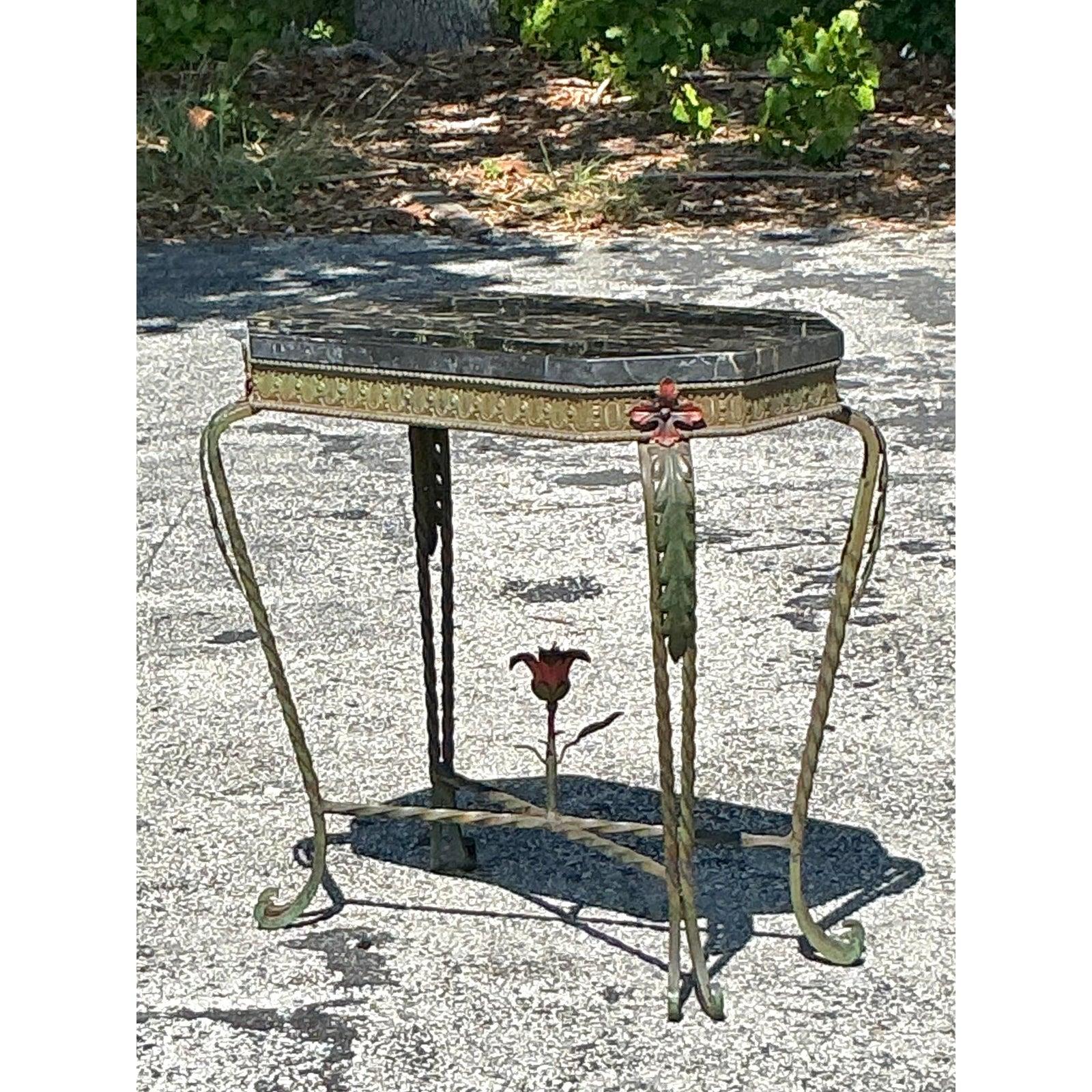 Infuse Art Deco glamour into your home with this striking vintage side table! A luxurious stone top, likely black and gold marble, rests upon an ornate wrought iron base featuring elegant curves, gilt details, and a charming central rose motif. This