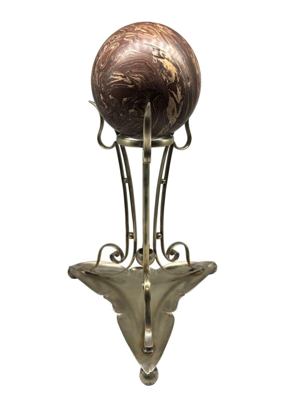 Voici un charmant objet de décoration vintage : un support en métal argenté orné d'une boule en bakélite. Ce support élégant dégage une sophistication intemporelle, alliant l'allure lustrée de l'argent à la chaleur de la bakélite. Parfaite pour