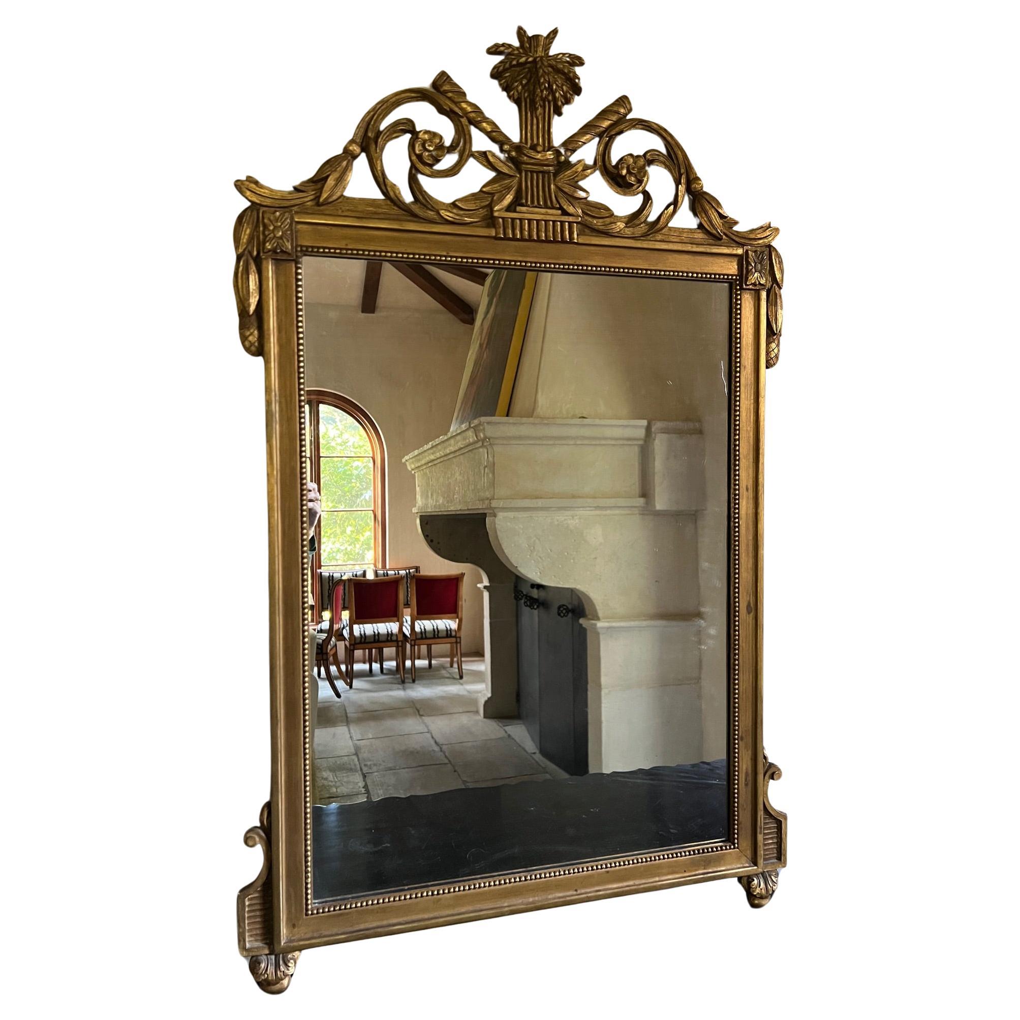 Vintage Decorative Arts, Inc., New York mirror in Louis XVI style with wheat, crowned by leaves and intertwined scrolls and flowers. The leaves go down each side with the corners embellished with more flowers, the frame is surrounded by wood