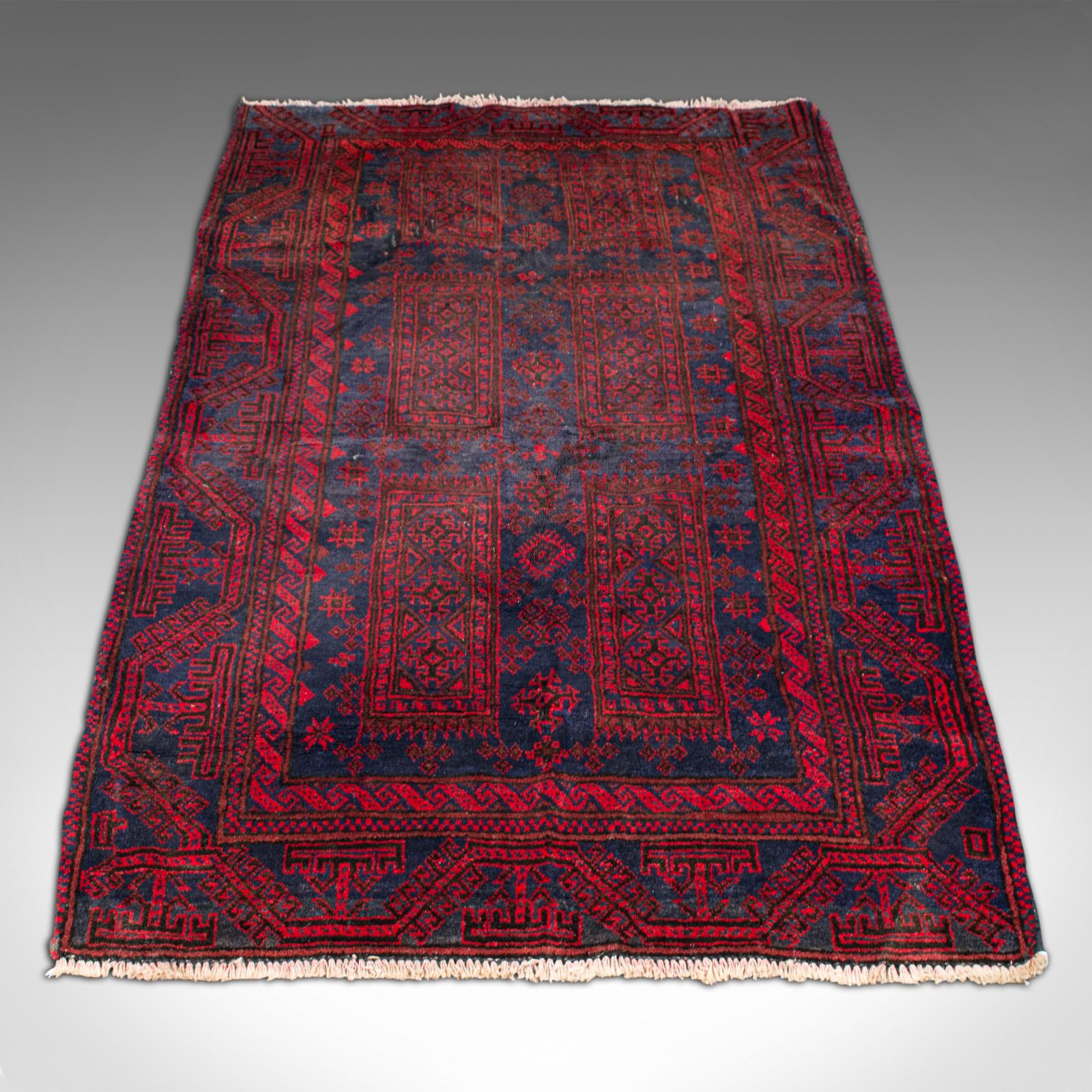 This is a vintage decorative Baluchi rug. A Middle Eastern, hand-woven hall or lounge carpet, dating to the early 20th century, circa 1930.

Of useful size for the doorway or beneath the coffee table at 93cm x 155.5cm (36.5