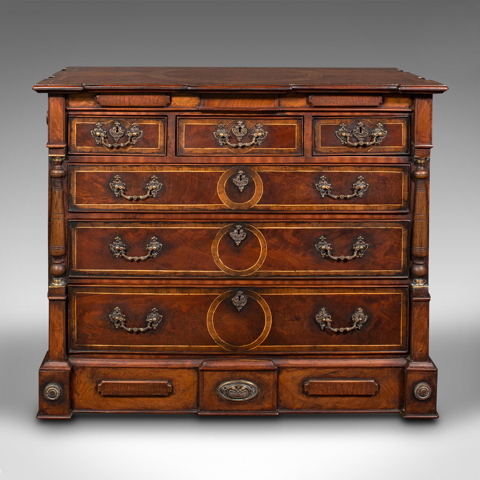 This is a vintage decorative chest of drawers. An English, mahogany and walnut drawing room storage cabinet in Georgian revival taste using quality antique stock, dating to the second half of the 20th century.

Striking and of fine craftsmanship,