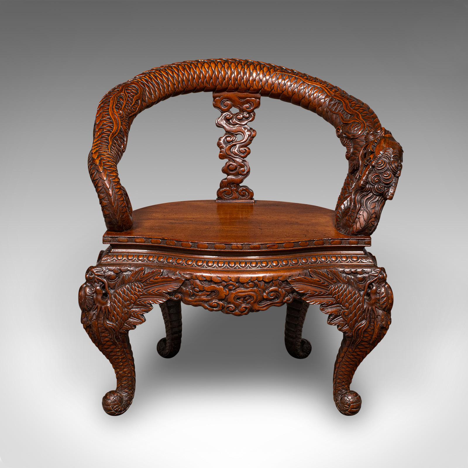 Si tratta di una sedia a gomito decorativa d'epoca, un sedile orientale in mogano intagliato a rilievo, risalente al tardo periodo Art Déco, circa 1950.

Raffinato pezzo d'epoca con un'accattivante lavorazione a rilievo
I fondi in mogano di qualità