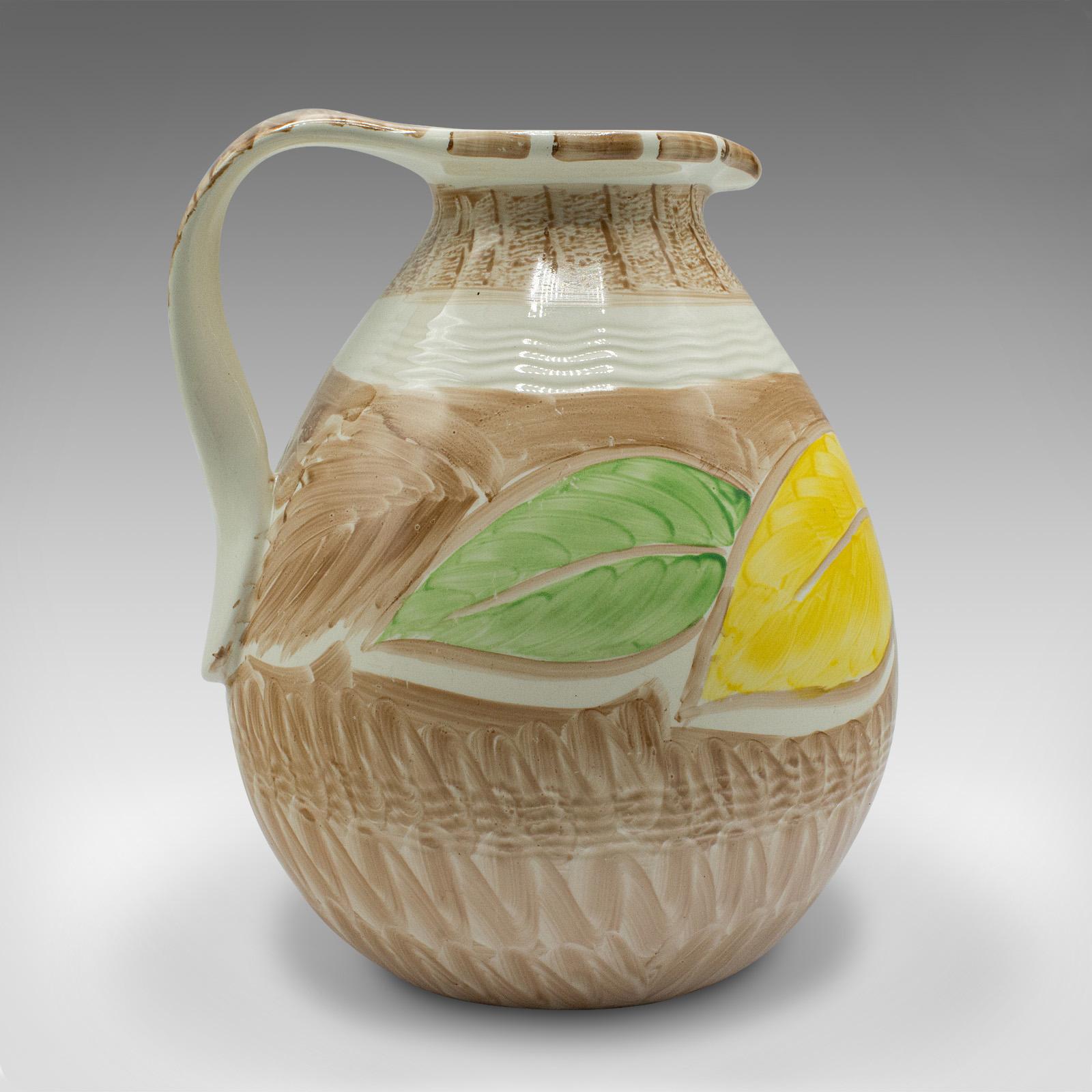 
This is a vintage decorative pouring jug. An English, hand painted ceramic creamer in Art Deco taste, dating to the early 20th century, circa 1930.

Delightful citrus decor accentuates this charming jug
Displaying a desirable aged patina and in