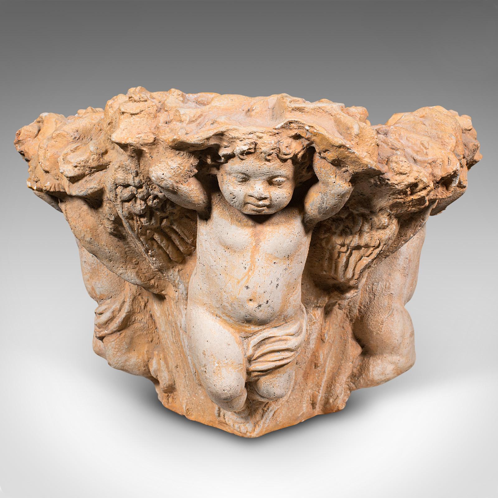 Dies ist ein dekorativer Vintage-Putti-Pflanztopf. Eine italienische, rekonstituierte Stein-Jardiniere mit Cherubfiguren, aus der Mitte des 20. Jahrhunderts, um 1950.

Faszinierende figurale Form mit kühnem Erscheinungsbild
Zeigt eine