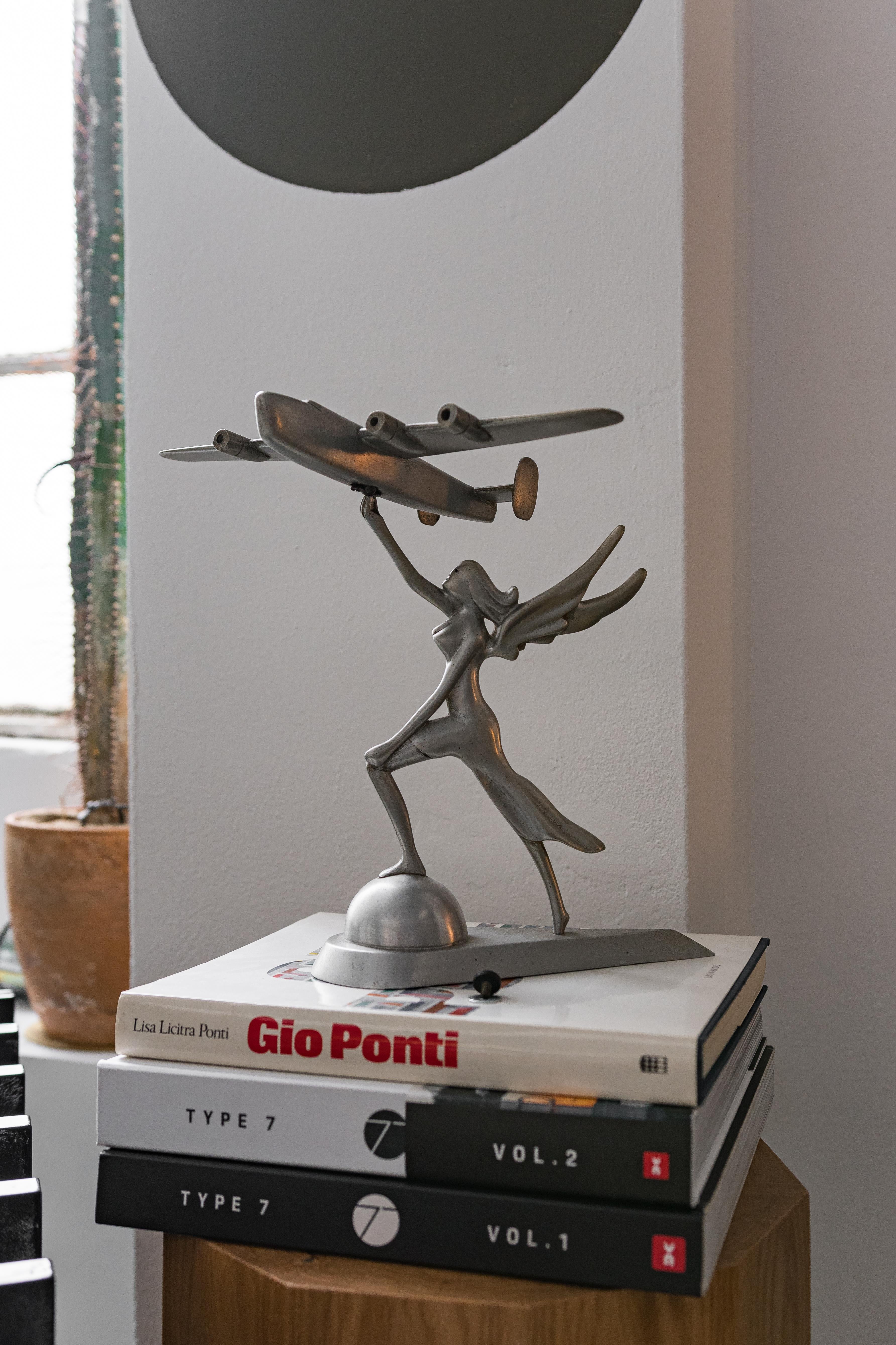 Mid-Century Modern Decorative Sculpture of a Goddess Holding a Consolidated B-24 Liberator For Sale