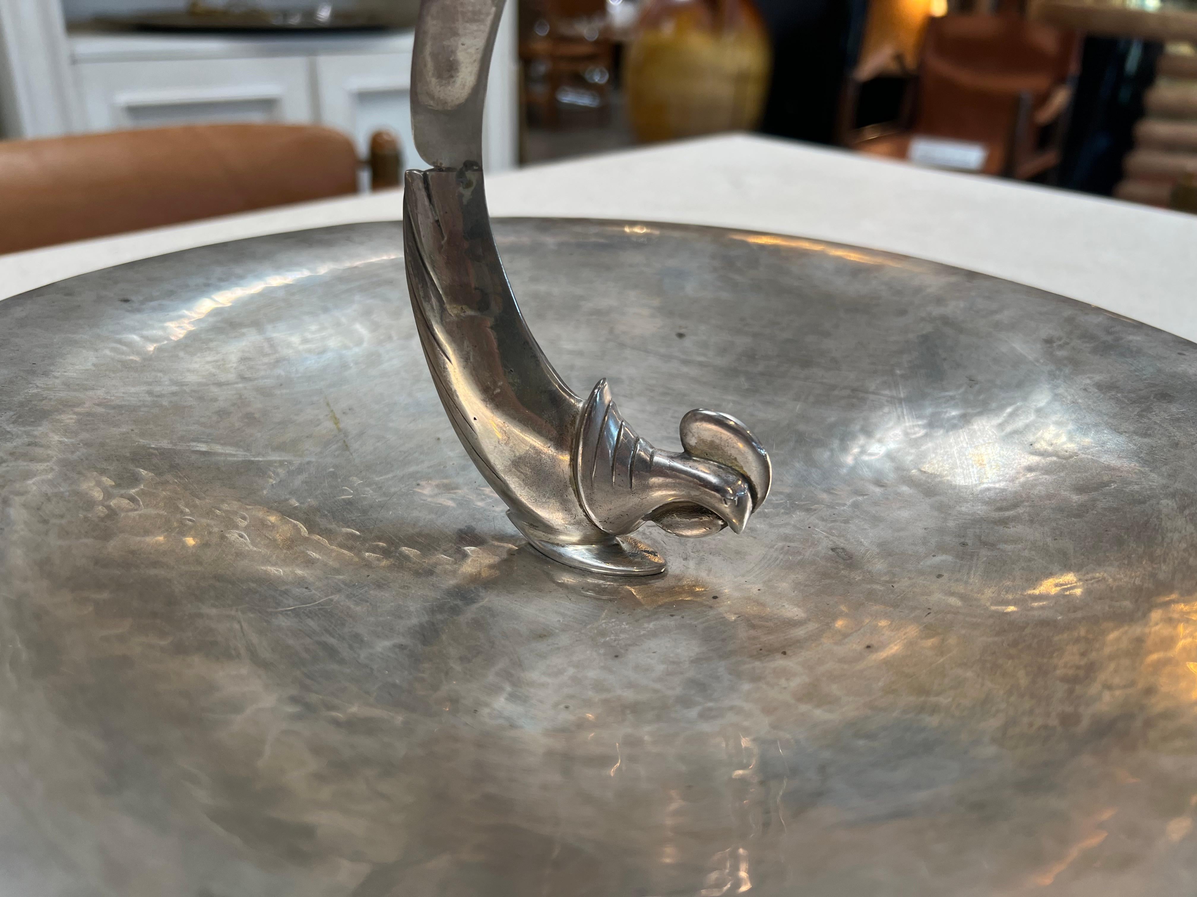 Certainly! The Vintage Decorative Silver Center Bowl from the 1960s is an ornate and collectible silver bowl, showcasing intricate craftsmanship and design typical of that era. It's a stylish and elegant piece that can serve as a centerpiece or