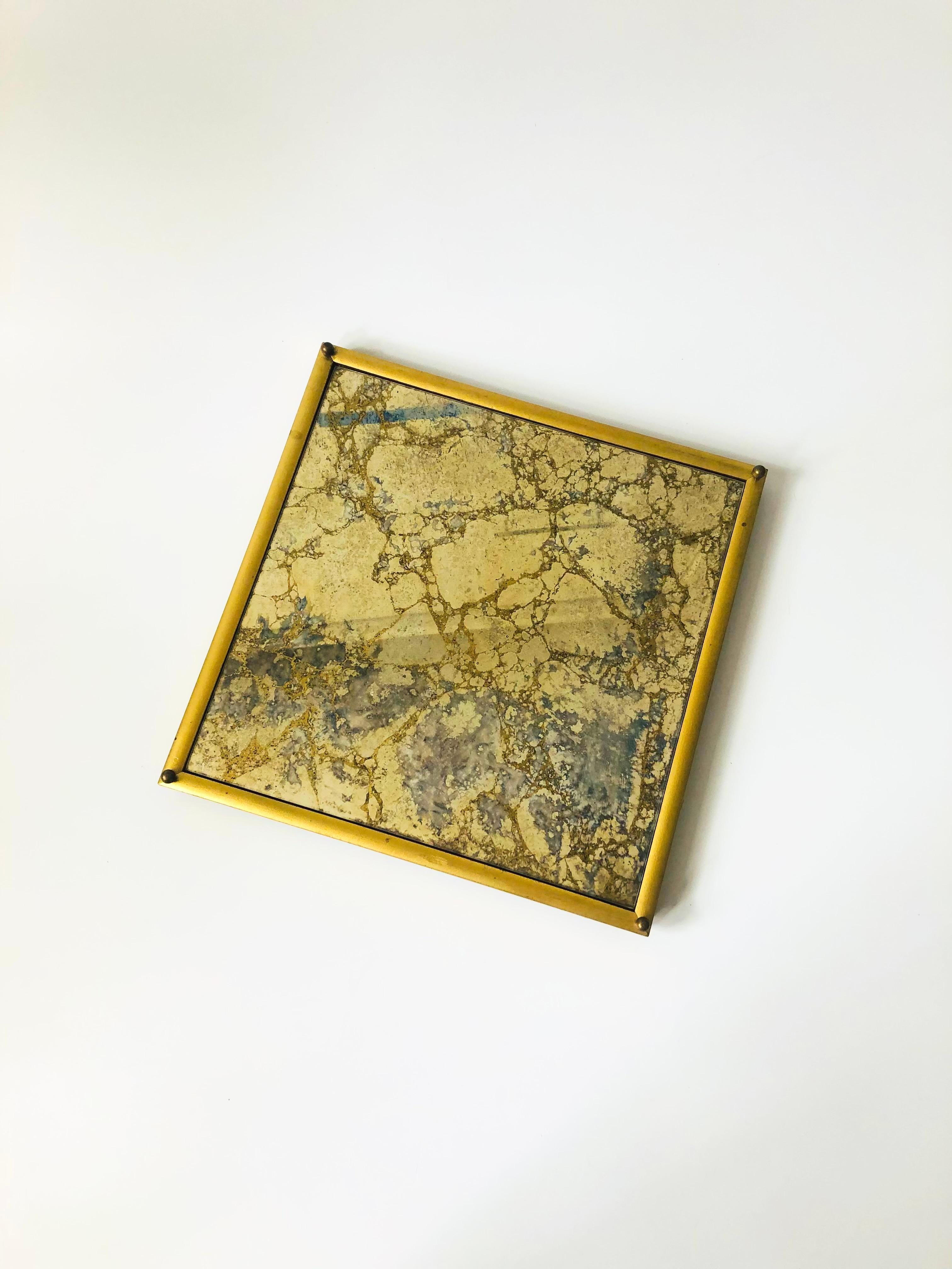 A mid century square mirrored tray. A beautiful decorative mirrored surface with gold detailing, mounted in a gilded wood frame.