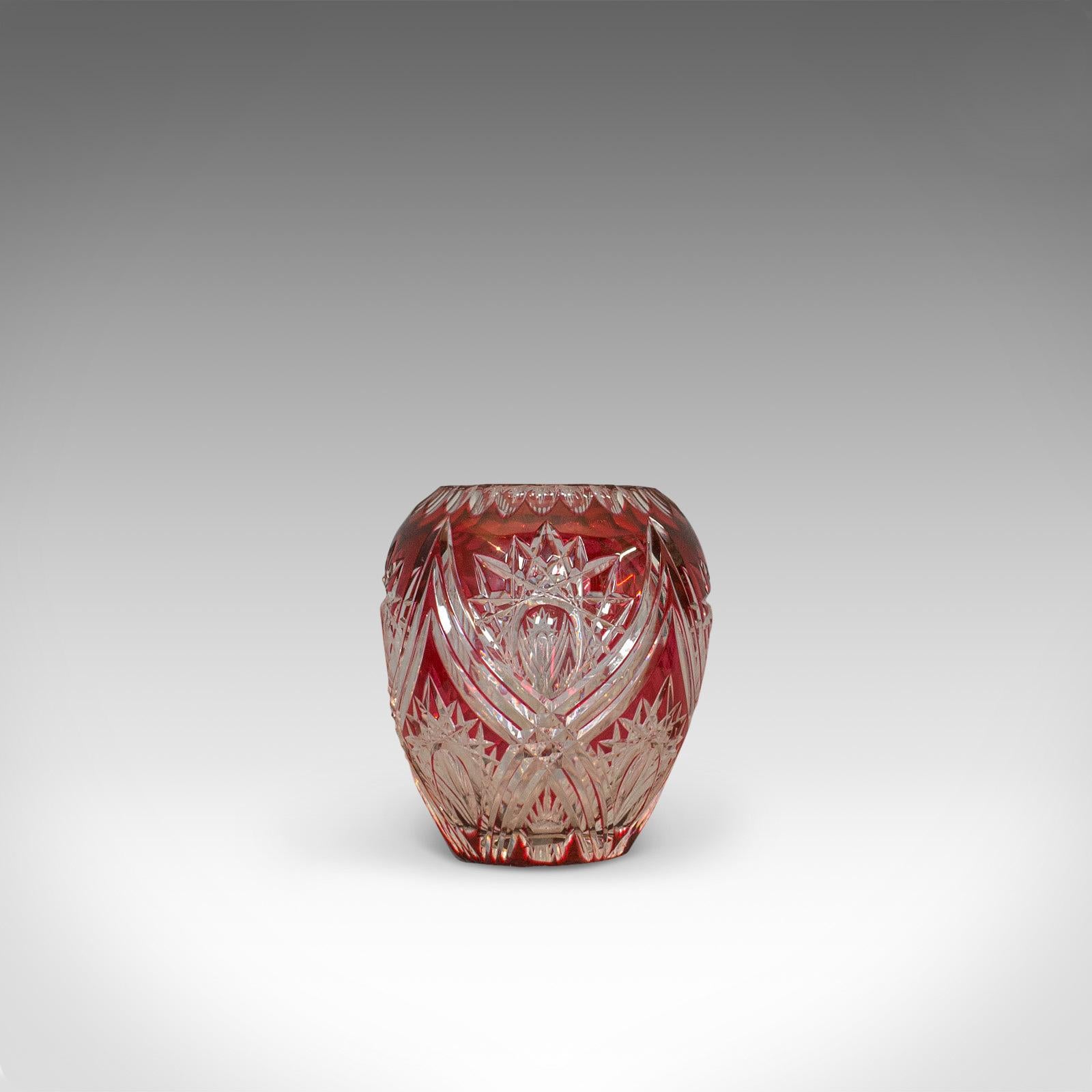 This is a vintage decorative vase. An English, cut glass vessel in rich cranberry color by Royal Brierley Crystal and dating to the mid-20th century, circa 1940.

Of sinuous form and with copious visual appeal
Cranberry hues with striking cut