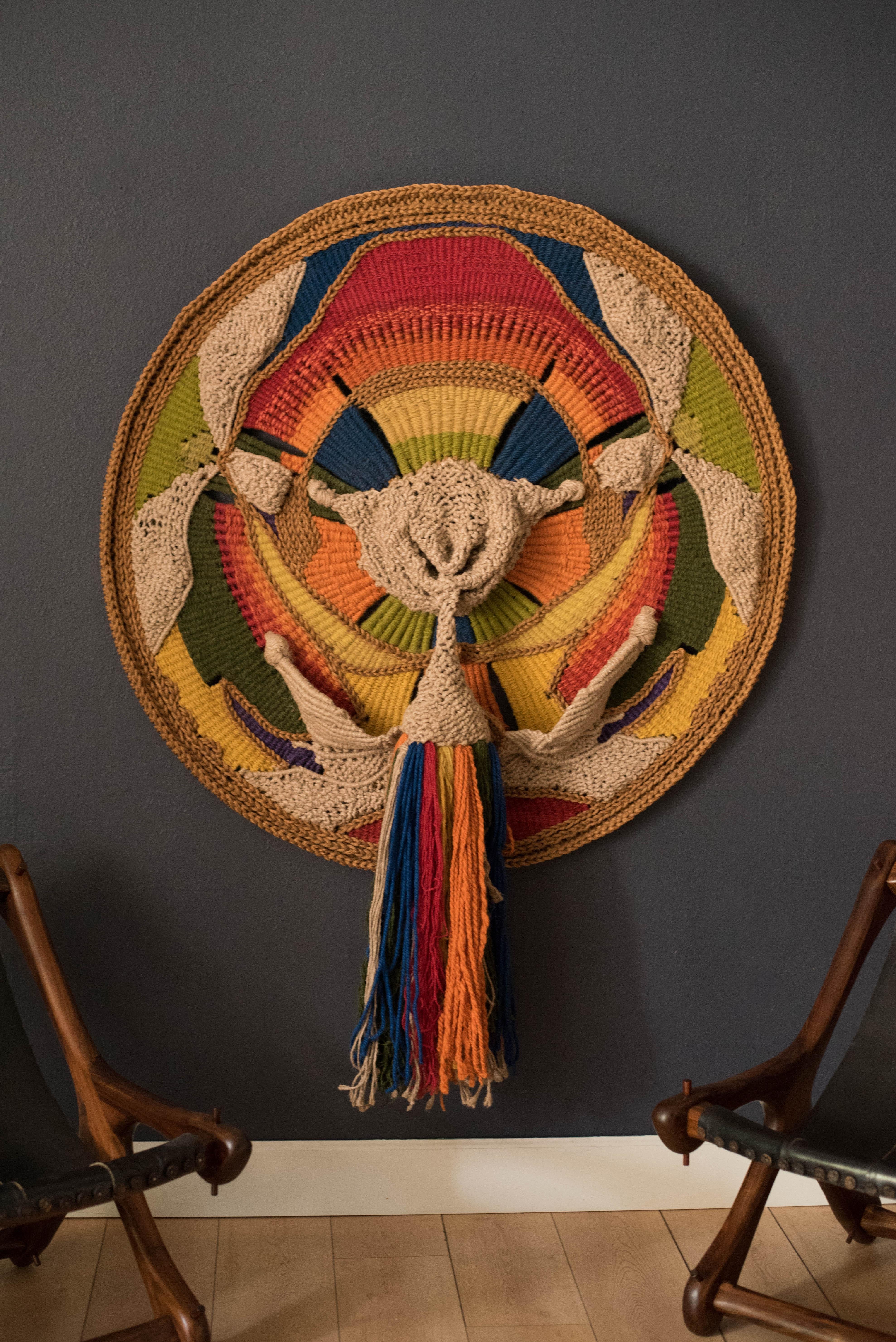 Vibrant colorful wall hanging fiber art tapestry made by California artist Marion Ferri, circa 1970s. This oversized piece features intricate hand woven natural and dyed fibers. Adds a soft texture and a pop of lively colors to any space. 

Includes