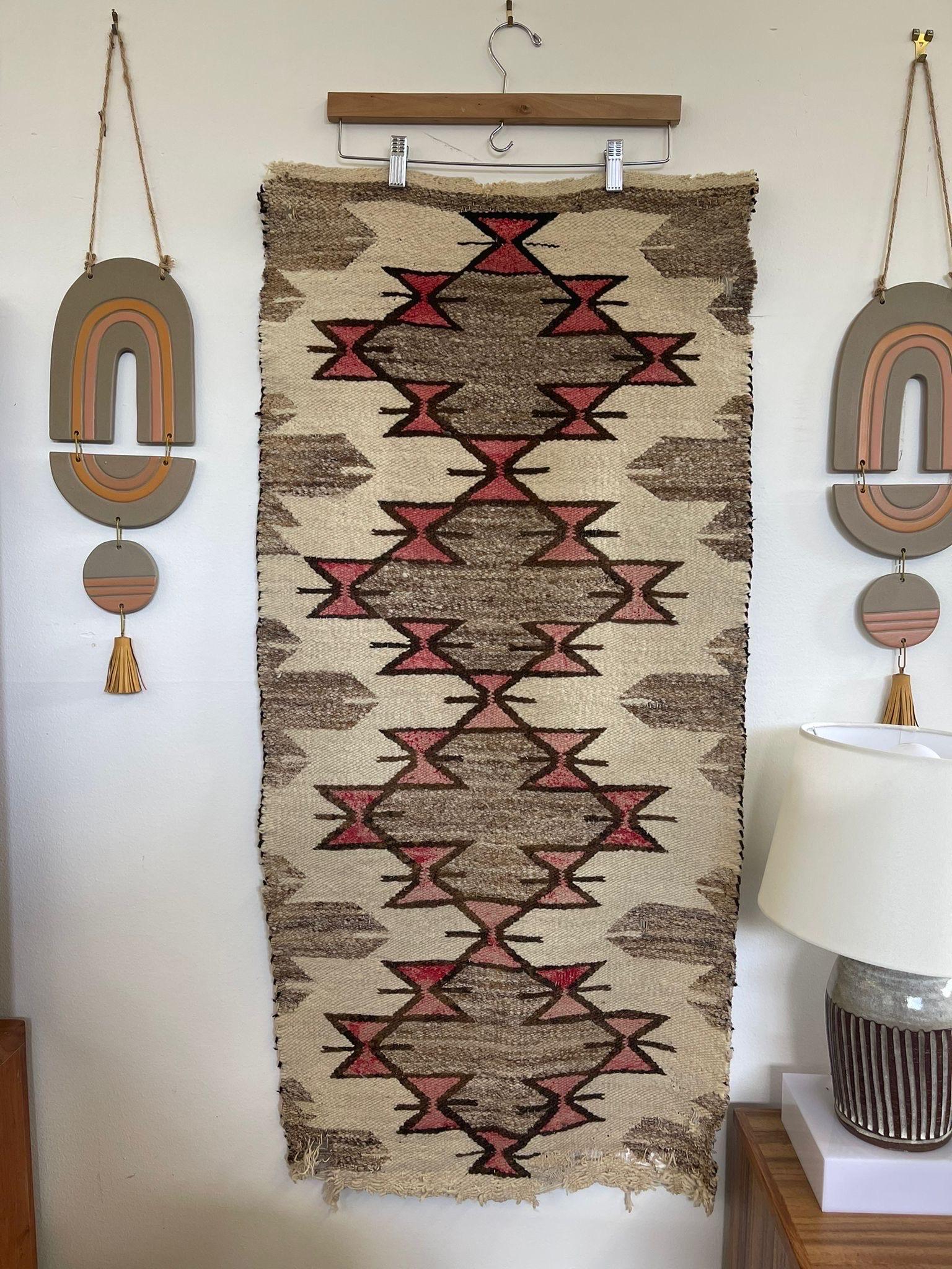 Primitive, traditional hourglass patterning on beige tone background. Corners are slightly frayed. Vintage Condition Consistent with Age as Pictured.

Dimensions. 44 L ; 21 W