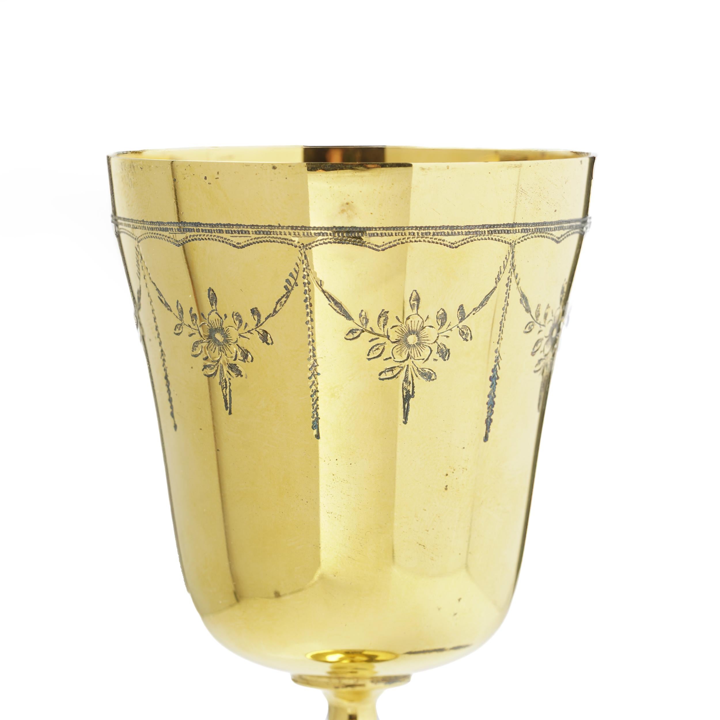 Un élégant gobelet en argent doré finement travaillé, fabriqué à Birmingham en 1970, présentant de charmants motifs floraux et festons gravés. La surface dorée brillante est magnifiquement complétée par des guirlandes gravées à la main et des têtes