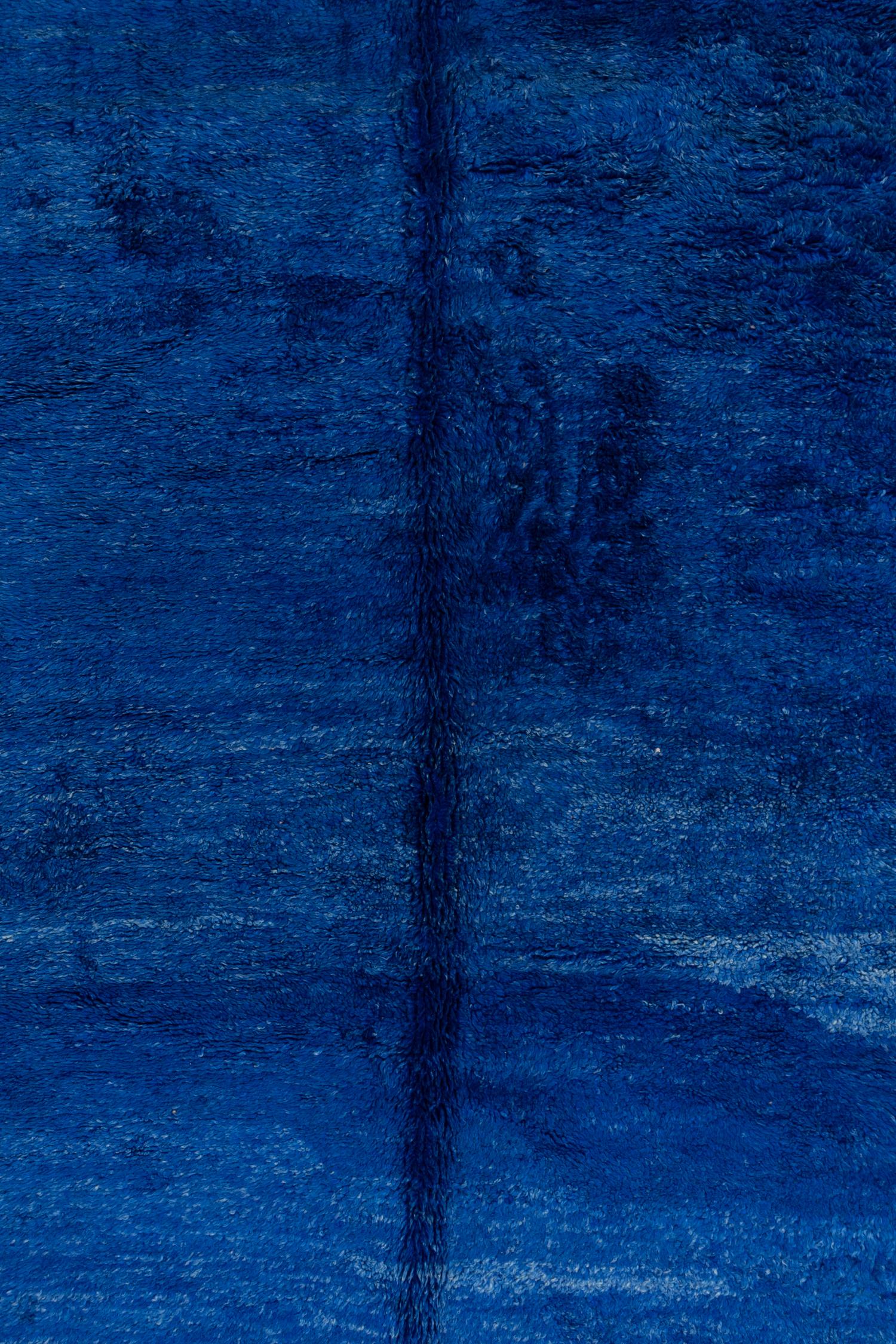 Der Beni Mrirt mit seinem satten, tiefblauen Farbton mit Abrasch wurde in den 1950er Jahren im Atlasgebirge in Marokko gewebt. Abgesehen von seiner atemberaubenden Farbe ist dieser Teppich einzigartig, weil er überdurchschnittlich breit ist, was bei