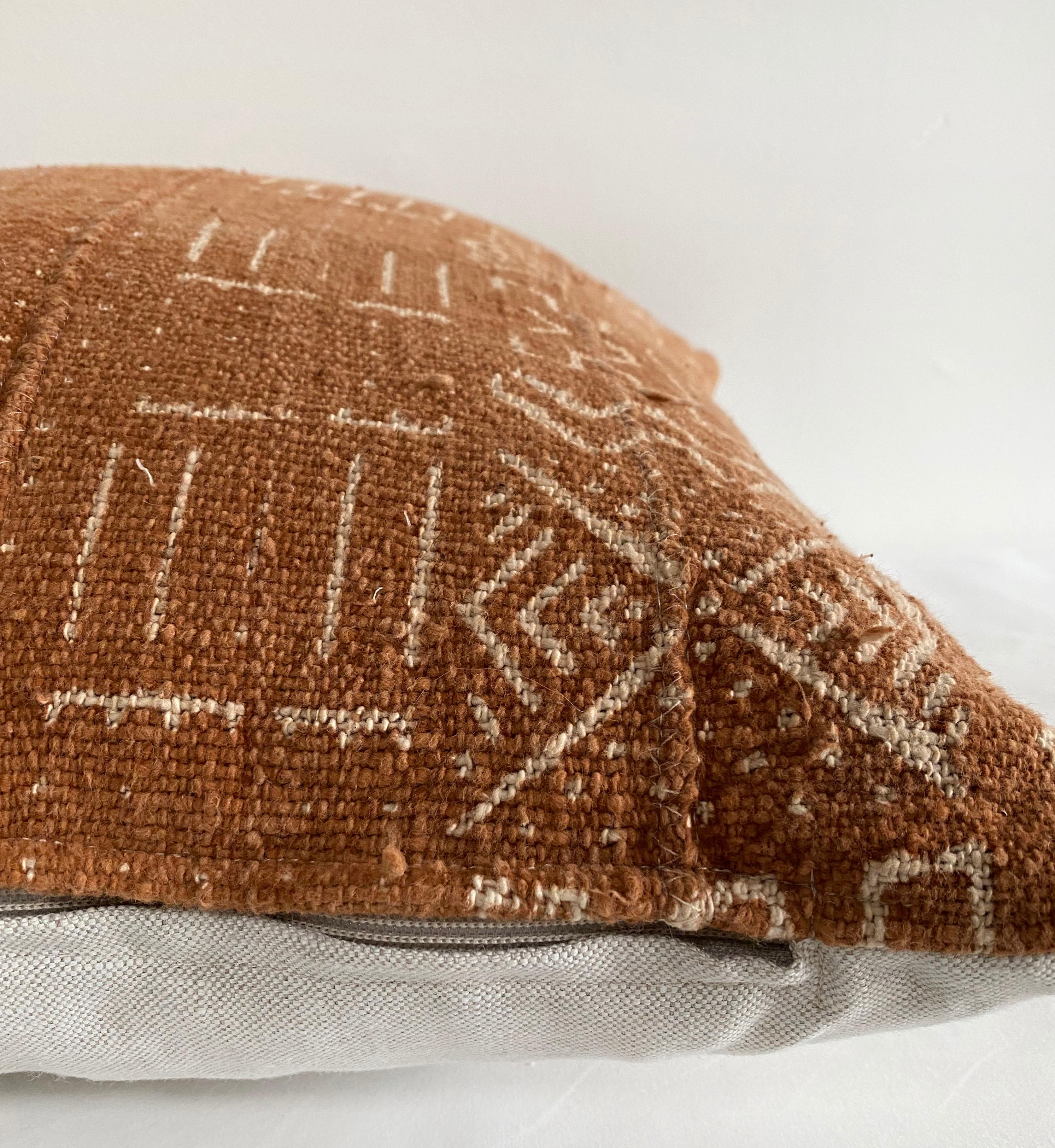 Vintage African Mudcloth pillows in a deep burnt orange rust color, with off white arrow pattern.
Sewn with a zipper closure, and natural linen backing. The inside has an overlocked edge, can be machine washed on gentle. For color fading dry clean