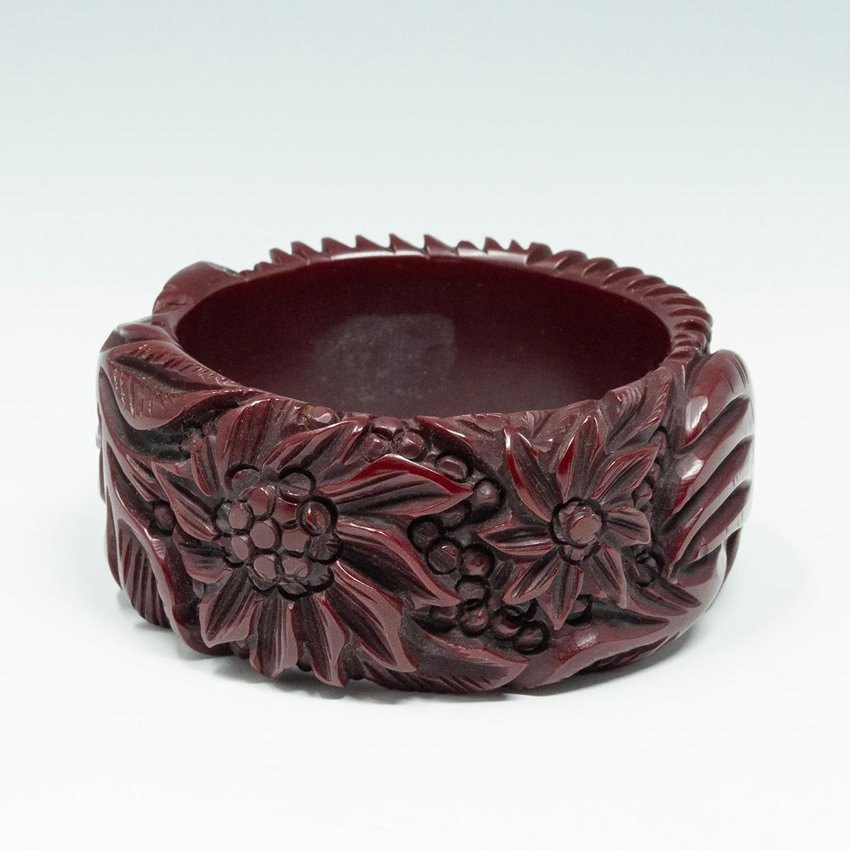 Vintage Bangle in bachelite bordeaux profondamente intagliato 

Questo raro braccialetto in bachelite è profondamente scolpito con due mani che tengono un bouquet di fiori. Il diametro interno è di 2,5 pollici e la larghezza o altezza è di 1,5