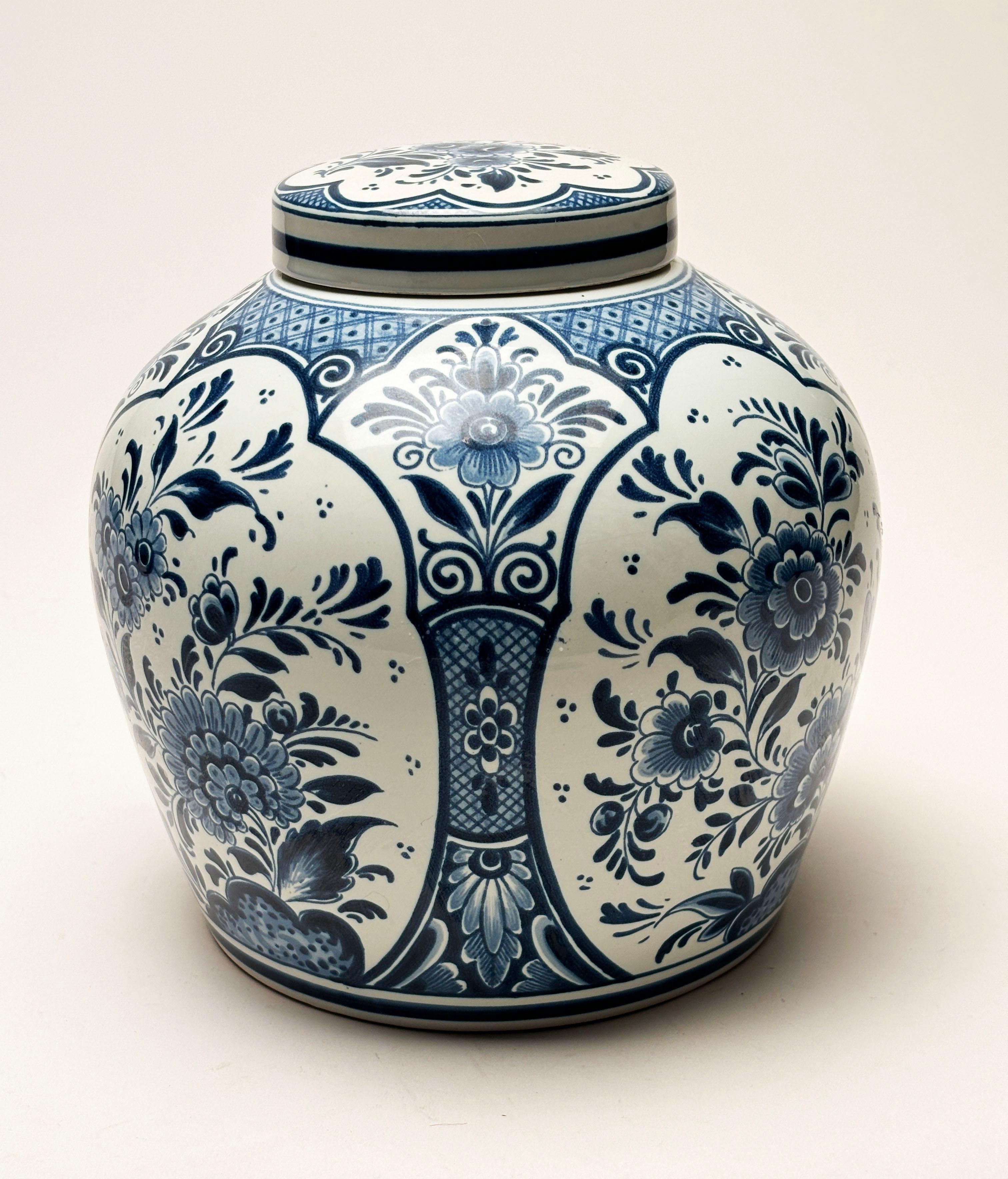 Ce magnifique pot à gingembre classique bleu et blanc de Delft avec couvercle est indispensable pour de nombreux décors. Les motifs floraux ornés sur le corps et le couvercle enveloppent de manière fantaisiste l'ensemble de la pièce, ce qui en fait