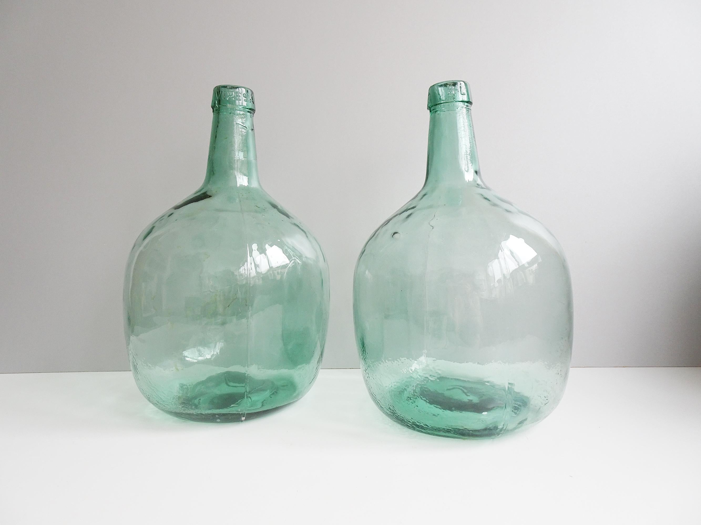 Two old Viresa glass bottles with a capacity of eight liters. The glass balloons have a refreshingly light green color with slight air pockets. Both demijohns are not perfect in shape, which gives them a great vintage character.