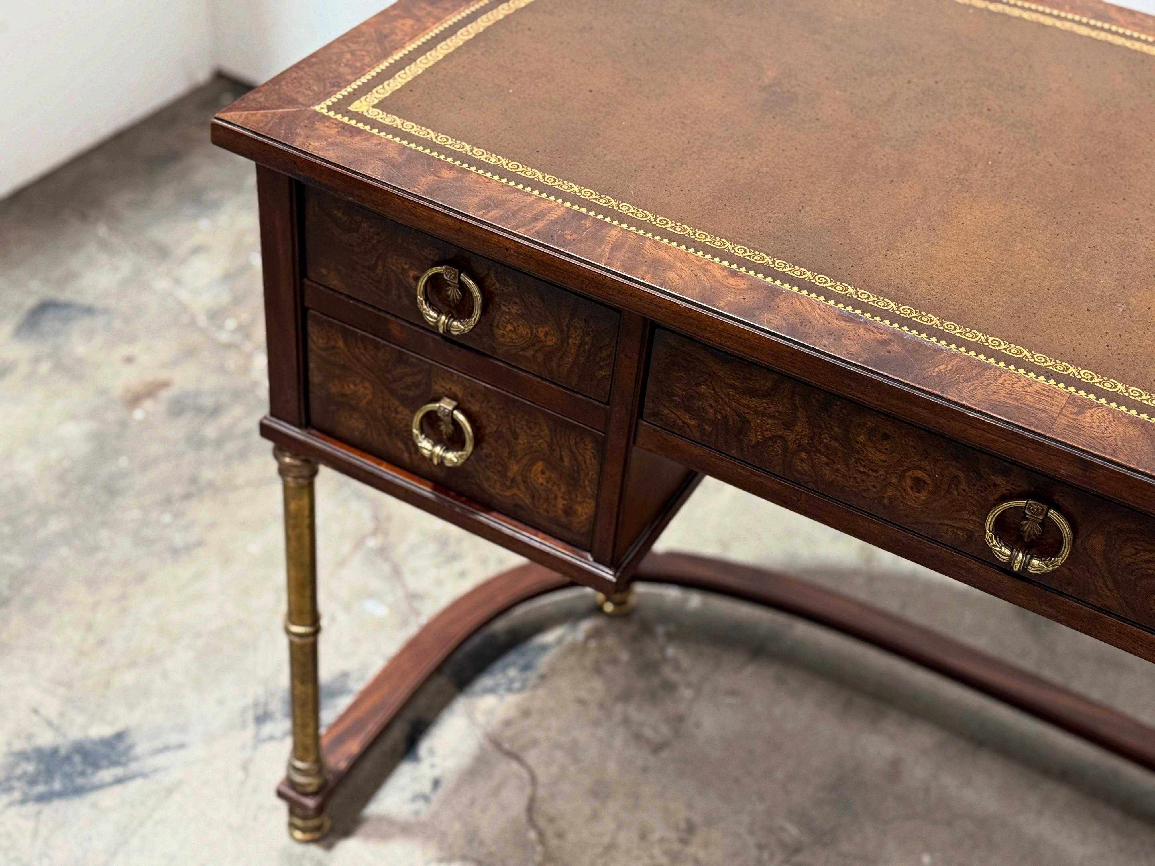 Vintage Campaign style demilune entryway desk by Sligh. Burled walnut, brass and leather. A small footprint with a ton of style.
Brass legs and hardware have a gorgeous slight patina to them. Inlayed leather top with gold tone tooling. Burl drawer
