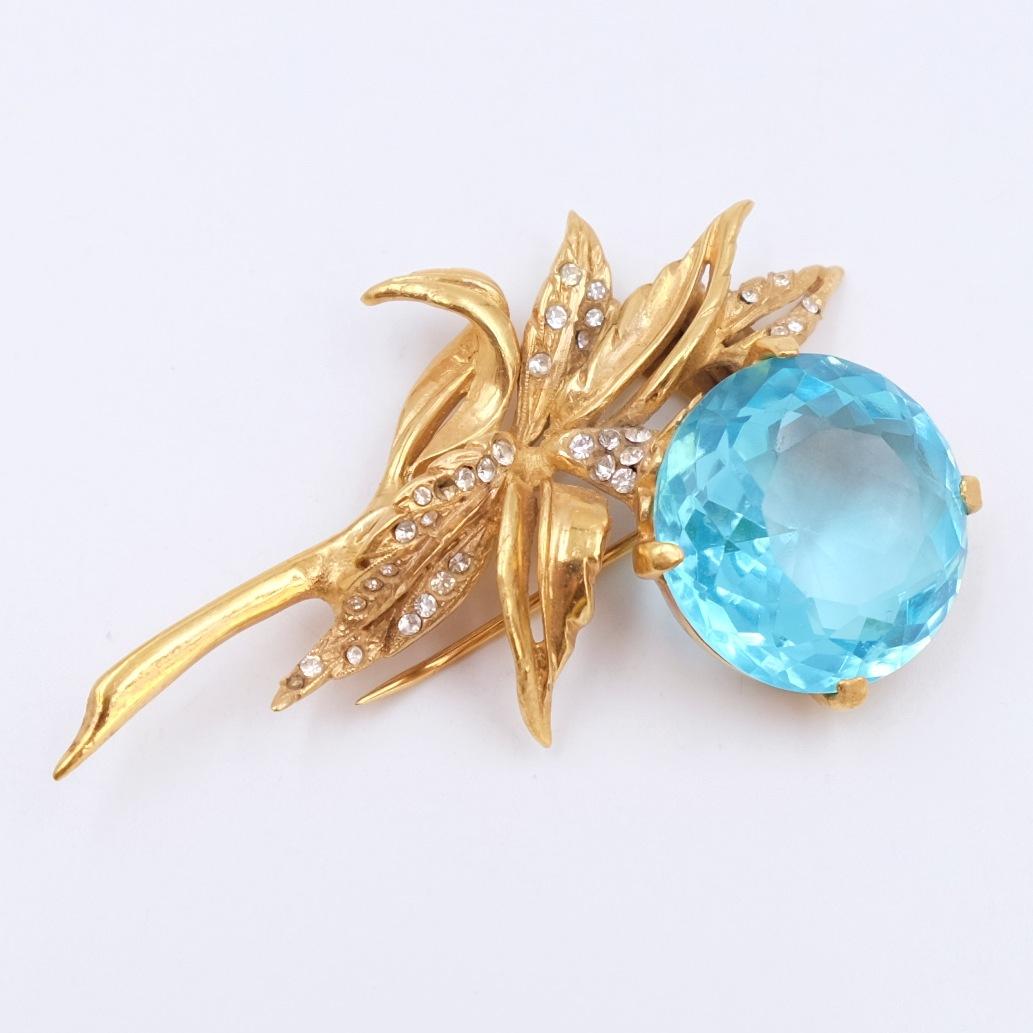 This charming DeRosa brooch in the shape of a flower is decorated with white rhinestones and a big blue crystal. 

Period: 1950s
Hallmark: R. DeRosa
Condition: perfect
Dimensions: H 2.8 Inch
Materials: sterling silver, rhinestones, faux