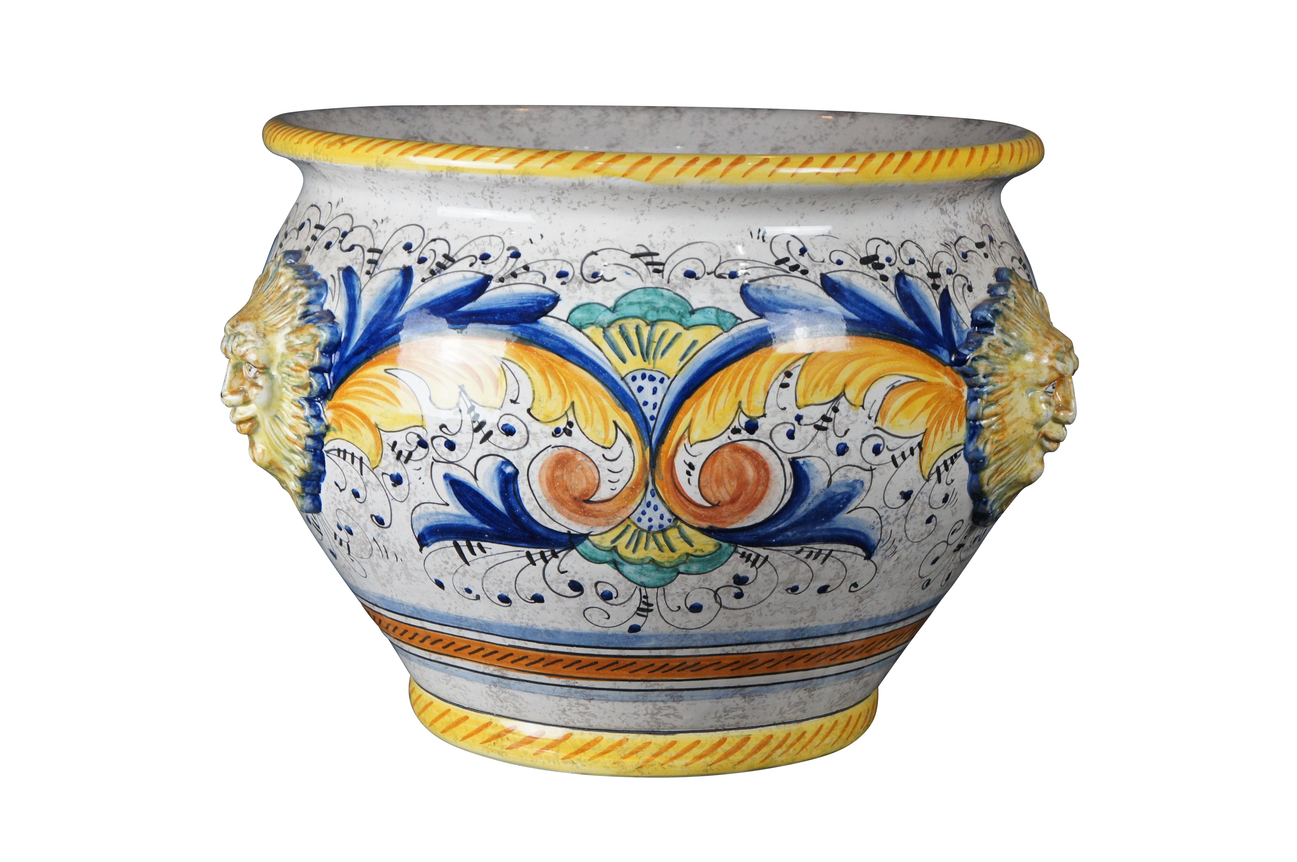 A beautiful 20th century jardiniere by Deruta pottery. Features a polychrome finish with elegant scrolling folitate motifs. The planter has three figural sunfaces along the exterior. 

Deruta Pottery was first produced in the 12th century, found its