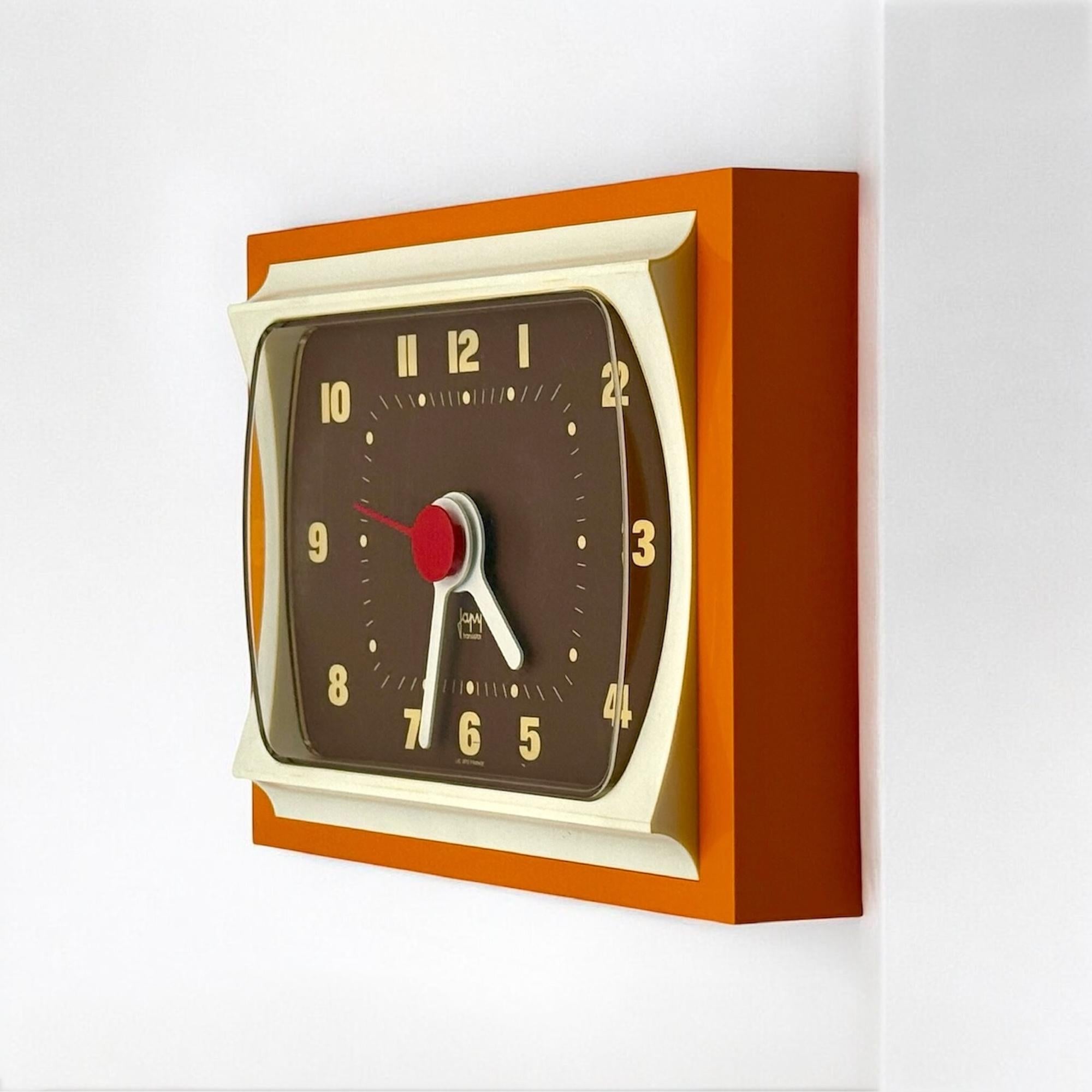 Striking 70s space age clock by Japy France perfectly blending retro futurism with bold visual flair. Featuring a large rectangular frame softened by curvaceous edges, it sports a vivid and warm color palette of mustard, brown and cream tones —an