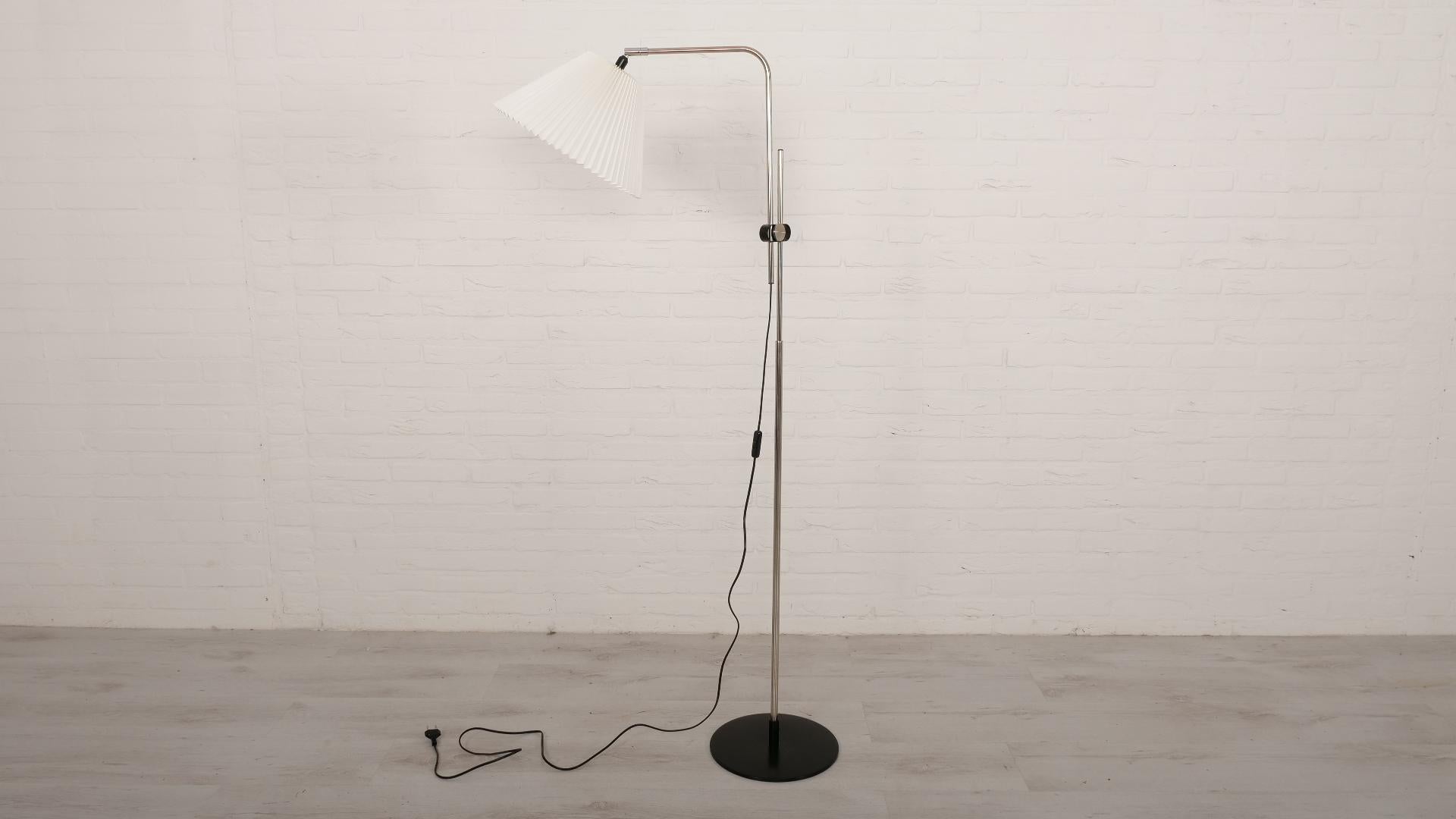 Gorgeous minimalist design floor lamp from Scandinavia! This vintage floor lamp was designed by Michael Bang and produced by Le Klint. This model, model 321, has a beautiful minimalist design with a metal stand, a black base a beautiful white