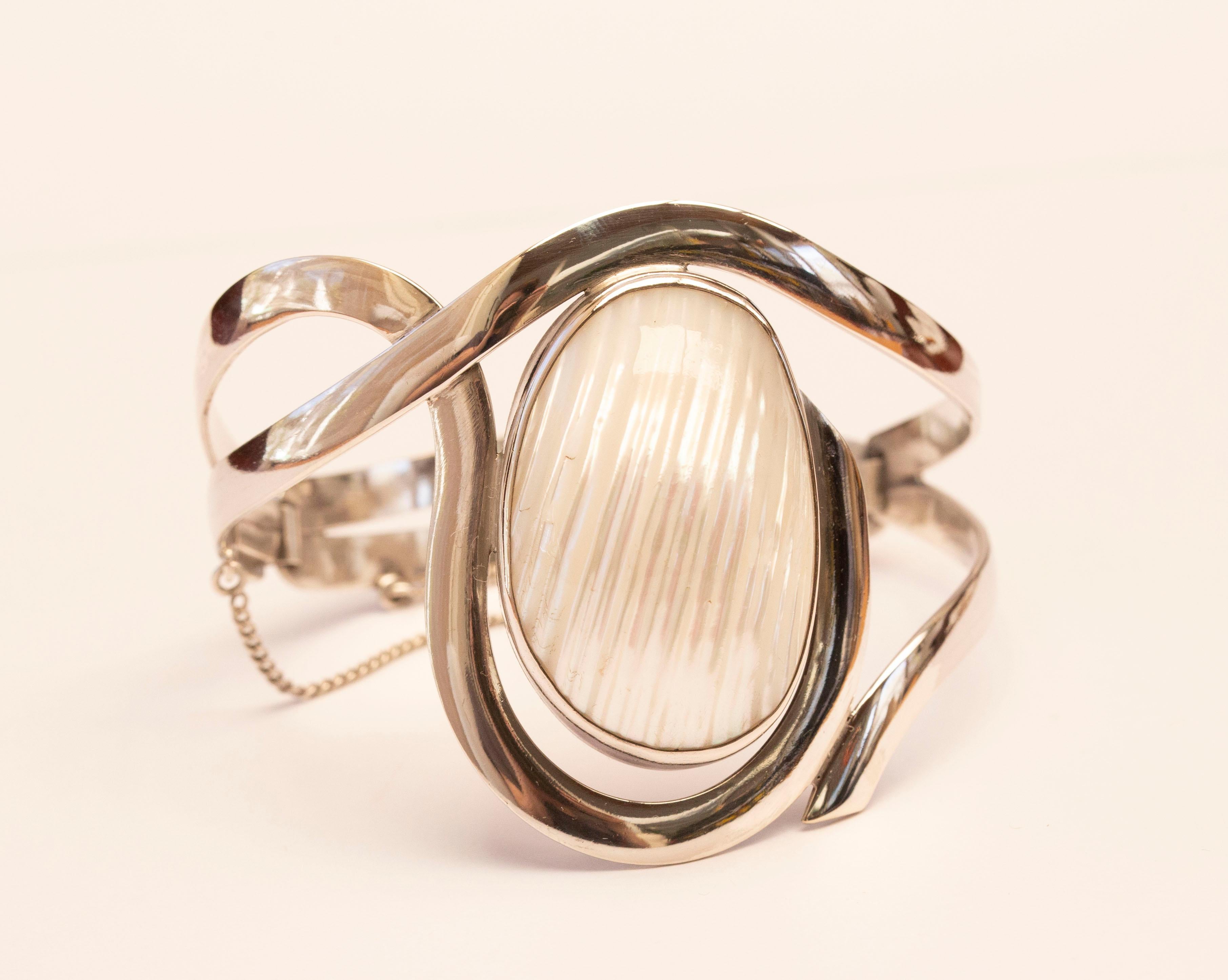 Un bracelet-bracelet en argent sterling polonais au design moderniste, orné d'un coquillage. Le bracelet est en argent 925/terling et porte les symboles correspondants de l'argent polonais. La fermeture du bracelet comporte une chaîne de sécurité.
