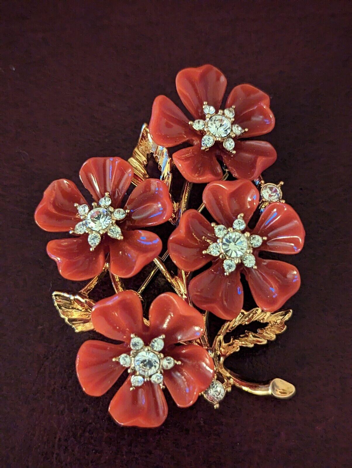 Simply Beautiful! Rare Vintage Designer Brooch by Nolan Miller featuring a Cluster of Red Lucite and Crystal Flowers. Center of Flowers Hand set with Sparkling Crystals. Gold Tone mounting. Measuring approx. 2.5