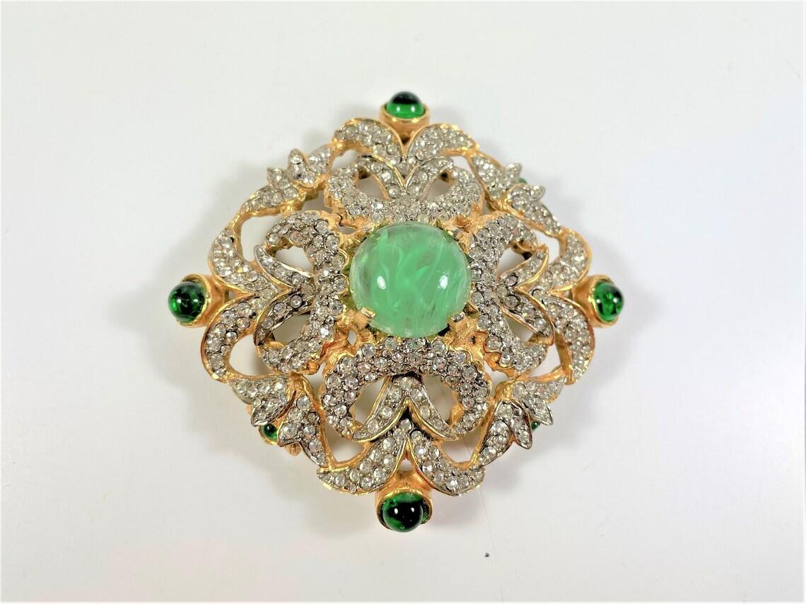 Simply Beautiful! Finely detailed Mimi Di N Brooch (Princess Mimi Di Niscemi) Brooch Pin. Signed NIPM Cartouche on back. Three-dimensional Brooch centering a Hand set marbled Green Glass Cabochon Stone. Surrounded by sparkling rhinestone Crystals,