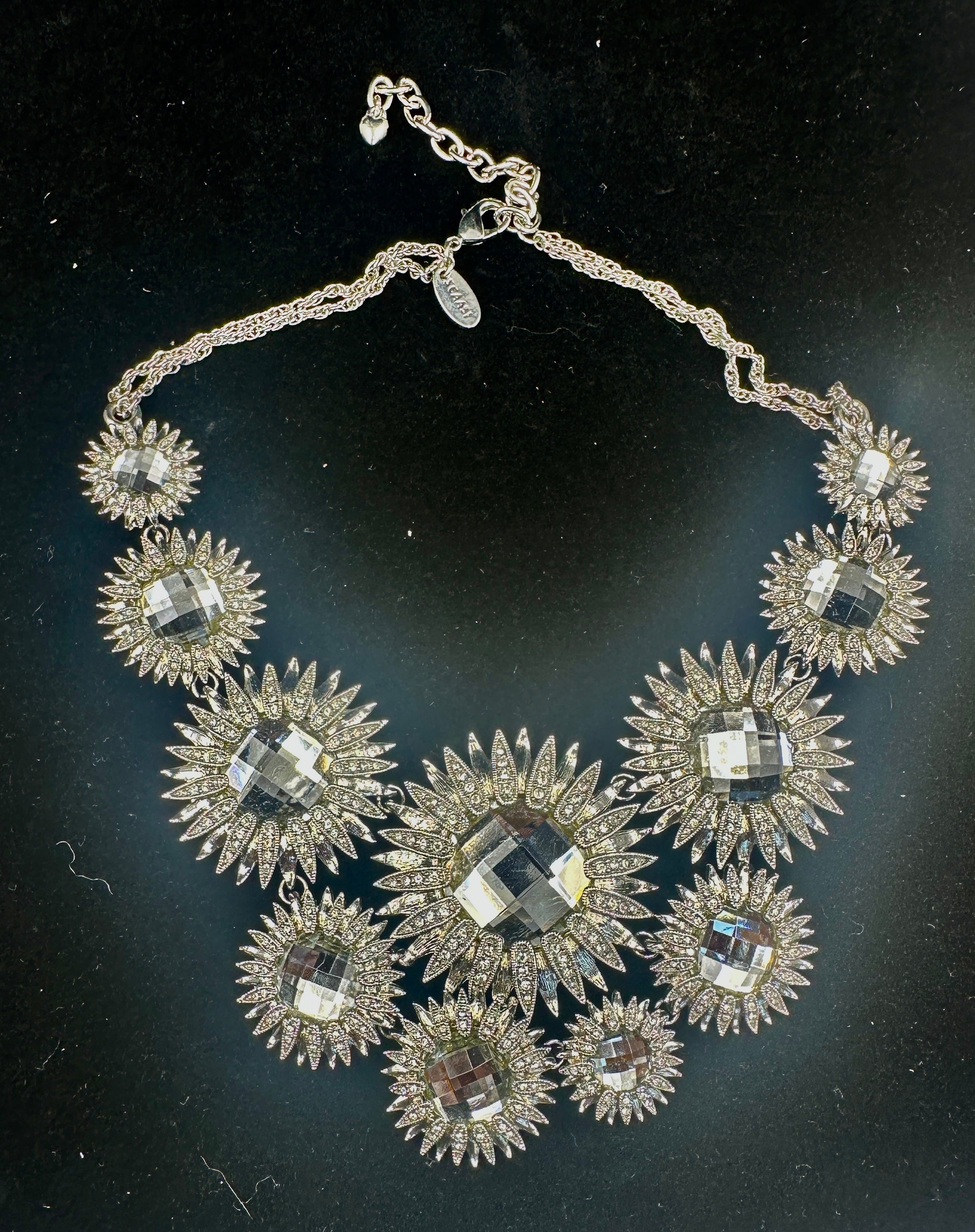 Dies ist eine prächtige Vintage By Scaasi Laufsteg-Halskette mit großen dramatischen Blumen- oder Sunburst-Sternmotiven mit facettierten Kristallzentren und Strassblättern.  Die fabelhafte Halskette legt sich wunderschön um den Hals und schafft ein