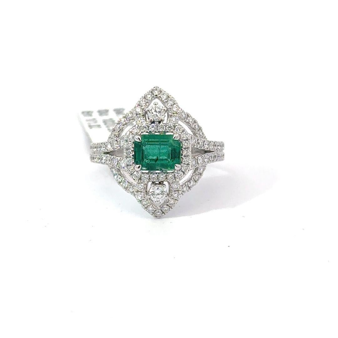 Introducing the pinnacle of sophistication – behold this exquisite emerald ring, encircled by a constellation of dazzling diamonds. The central emerald, meticulously cut to showcase its profound verdant tones, stands as a timeless testament to