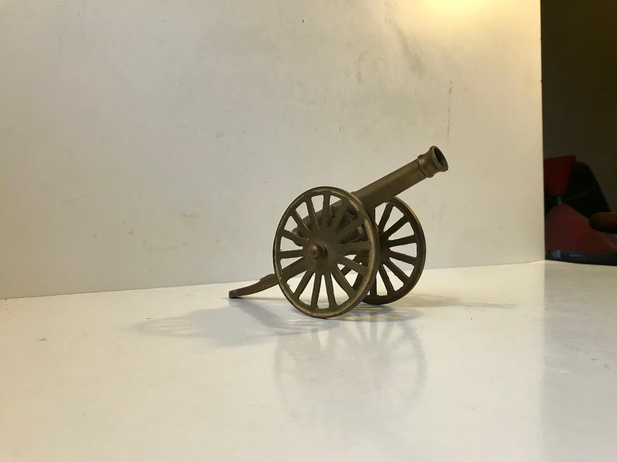 A mans paperweight or desktop ornament. Vintage German model of a World War 1 artillery canon. It is fashioned out of cast brass and was made circa 1970 or perhaps a bit earlier.