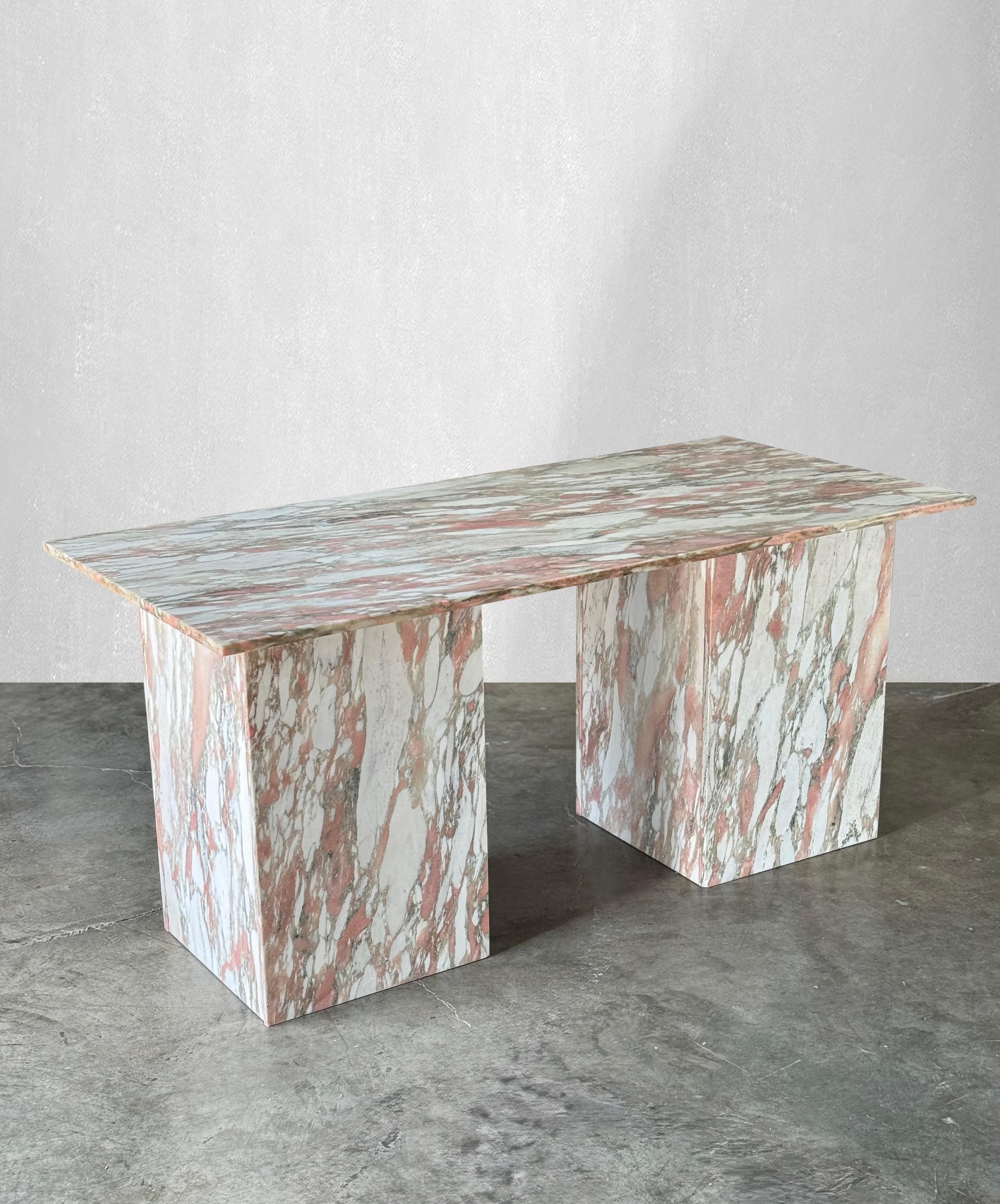 Striking marble desk that is made of Norwegian Rose Marble. The solid top sits on two matching bases. Norwegian Rose marble consists of shades of pinks, grays and cream.

The natural veining is dramatic and striking.

There is plenty of leg room for