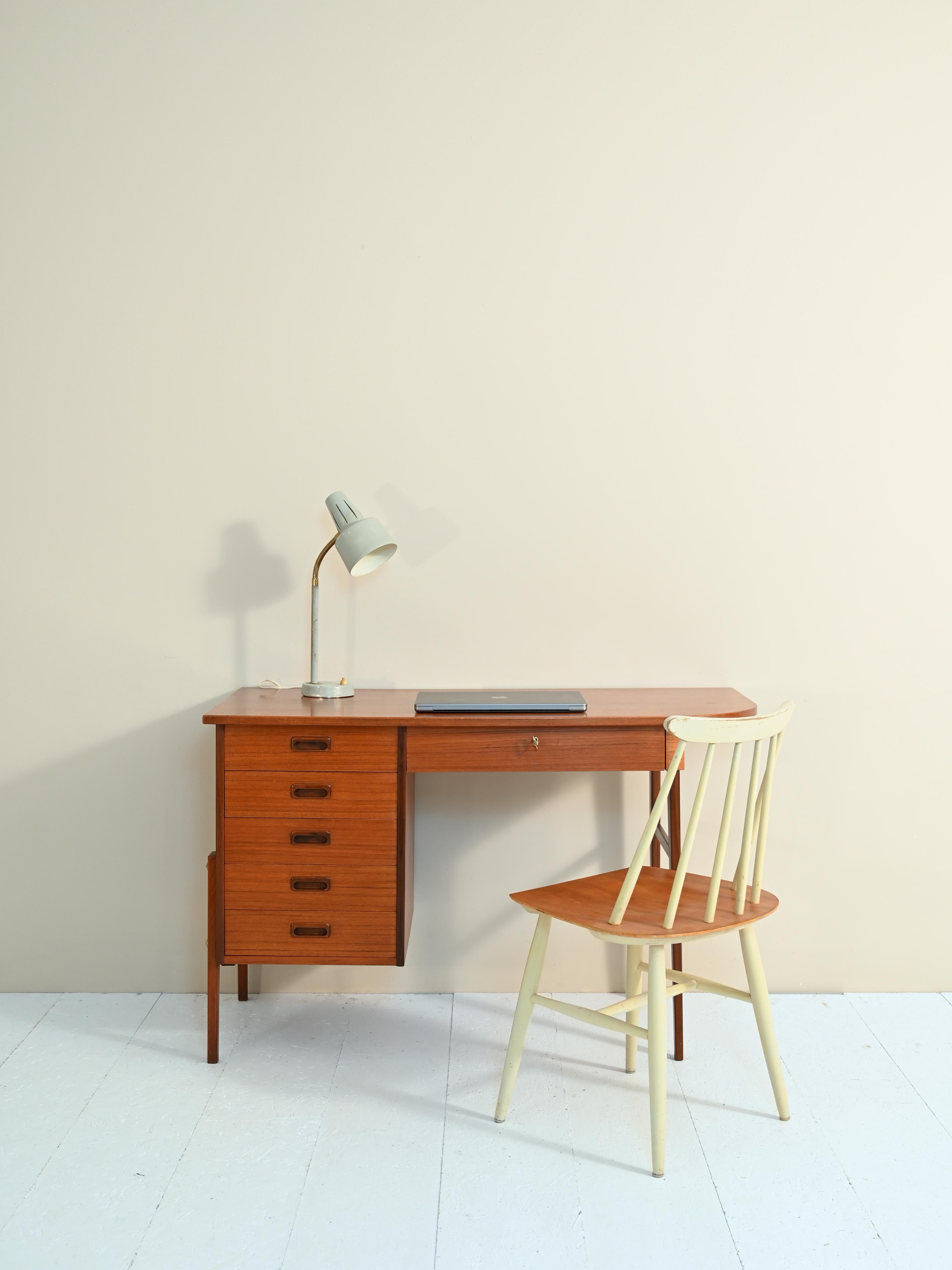 Mid-century teak desk equipped with drawers.

The regular structure features five drawers on one side and a lockable drawer on the other side.
 
The carved wood handle of the drawers as well as the fineness of the details are evidence of the