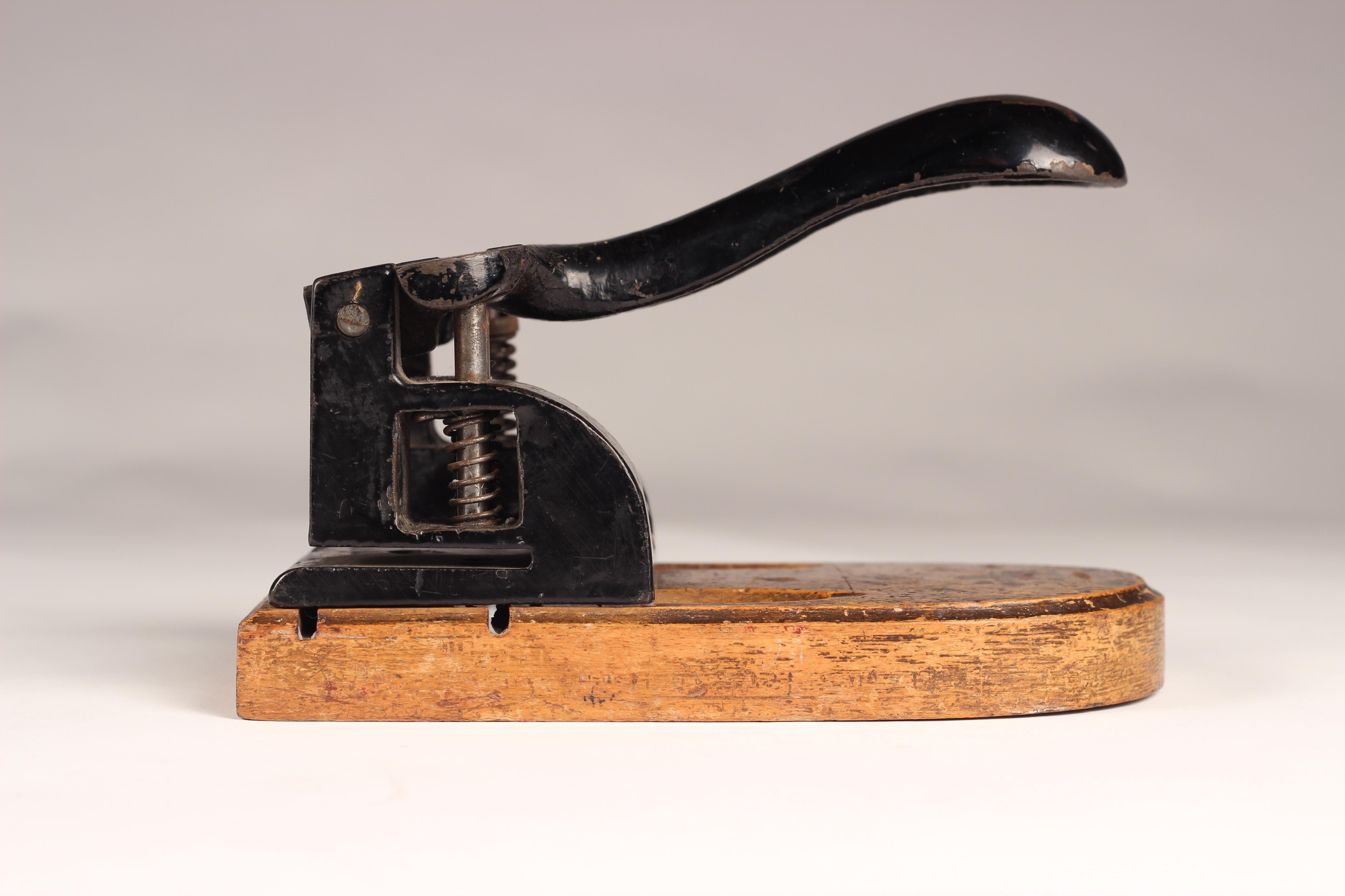 A vintage heavy duty metal, fully functioning hole punch mounted on oak base found in the Lake District in the North of England.