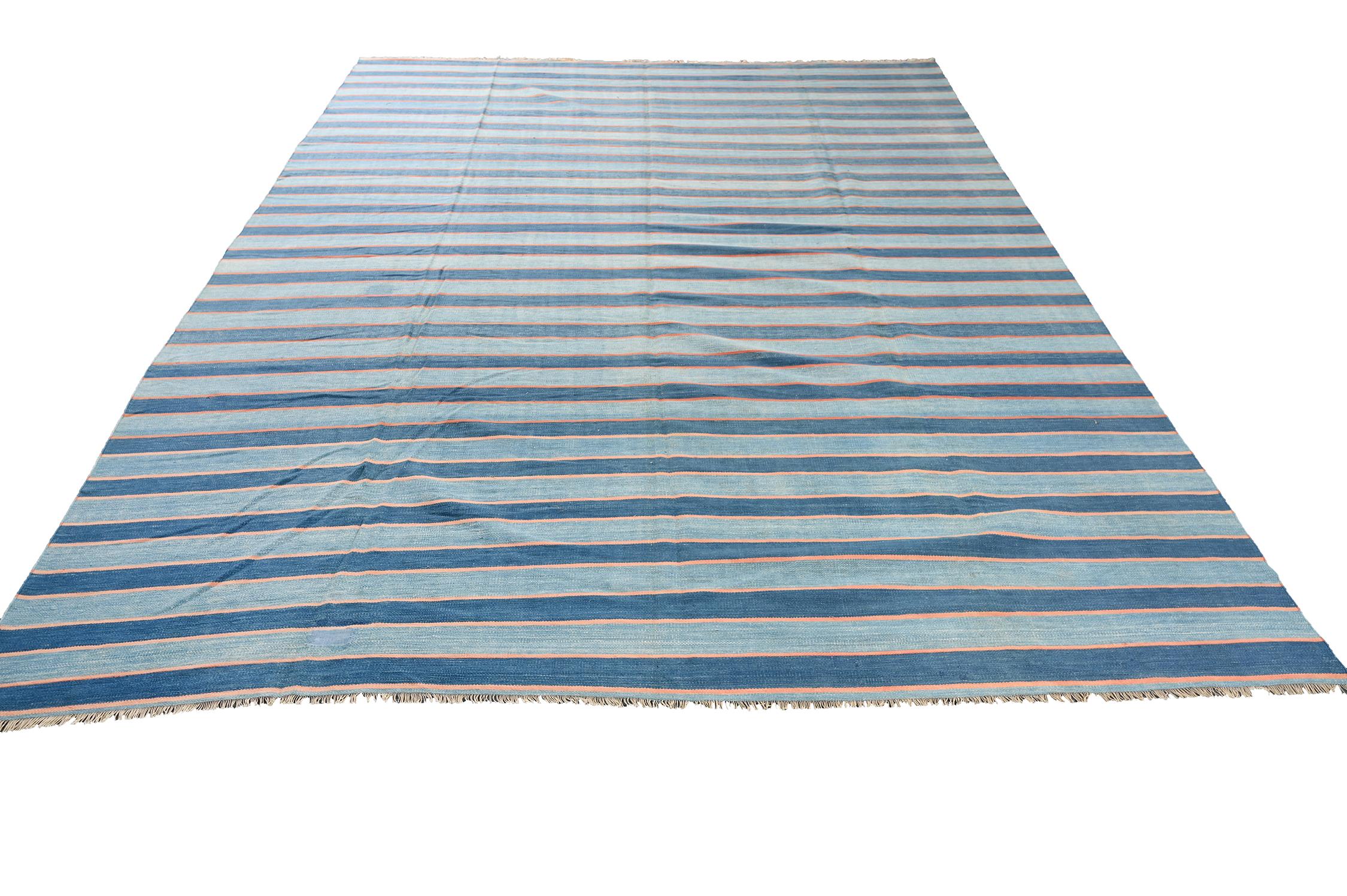 This vintage 9x12 Dhurrie is an exciting new entry in Rug & Kilim's esteemed flat weave collection. Handwoven in cotton, it originates from India circa 1950-1960. 

Further on the Design:

This flat weave prefers a simple series of stripes in