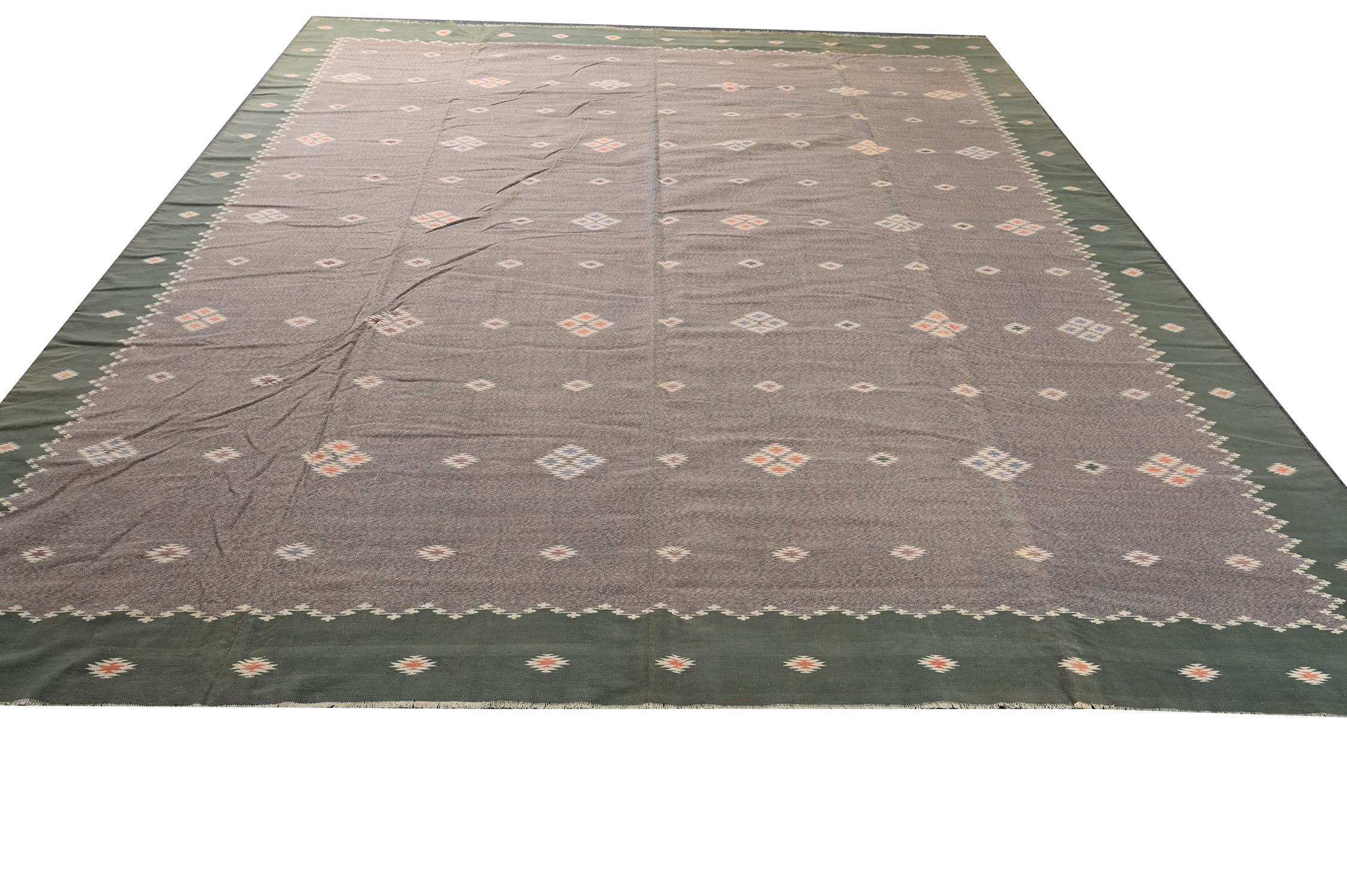 This vintage 11x13 Dhurrie is an exciting new entry in Rug & Kilim's esteemed flat weave collection. Handwoven in cotton, it originates from India circa 1950-1960. 

Further on the Design:

This flat weave enjoys a taupe field and green border
