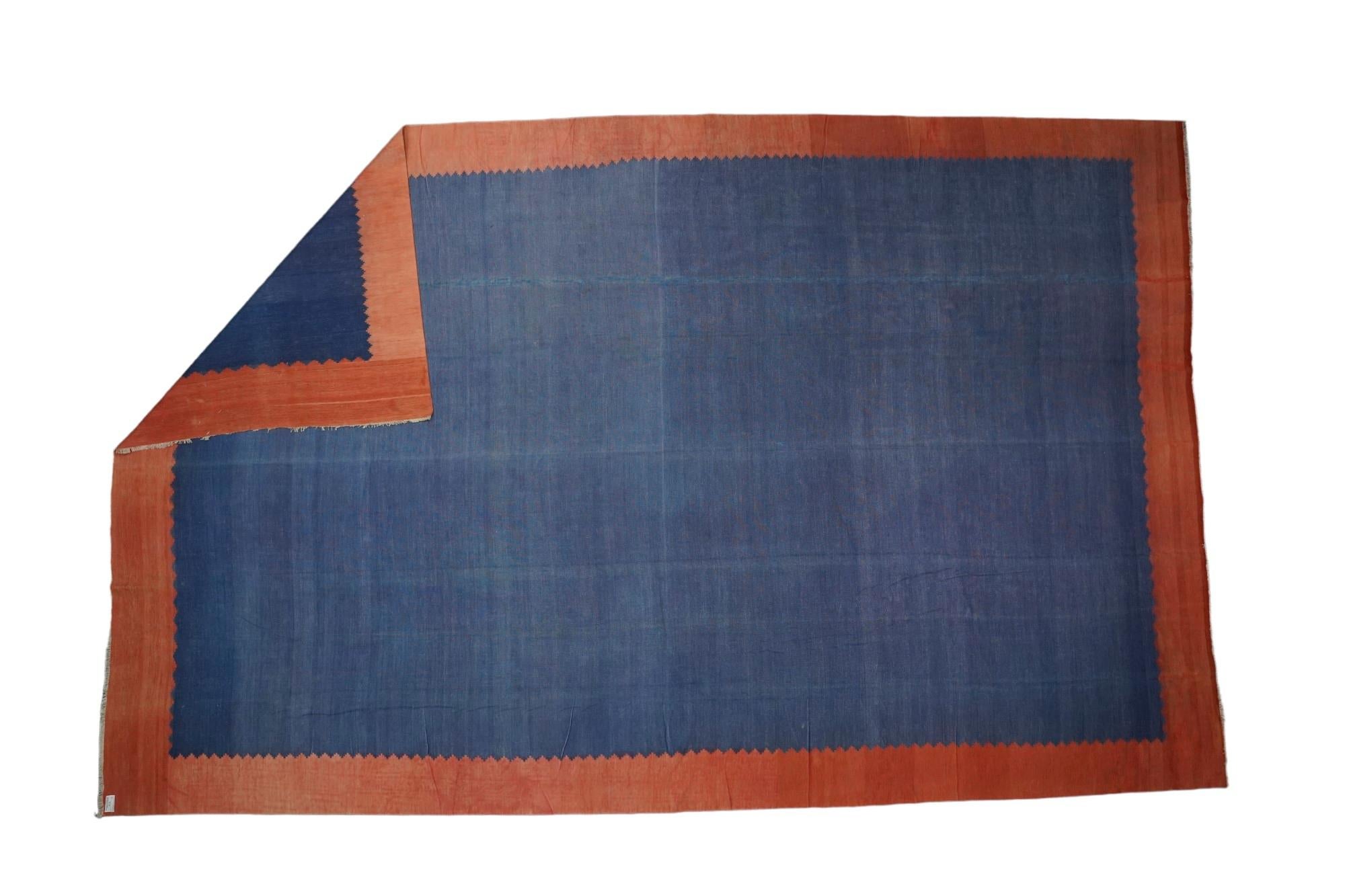 This 11x16 rug is a rare vintage Dhurrie rug from an exciting new mid-century curation by Rug & Kilim. Handwoven in a wool flatweave, it originates from India circa 1950-1960, and enjoys a blue open field and solid red border. 

On the Design: