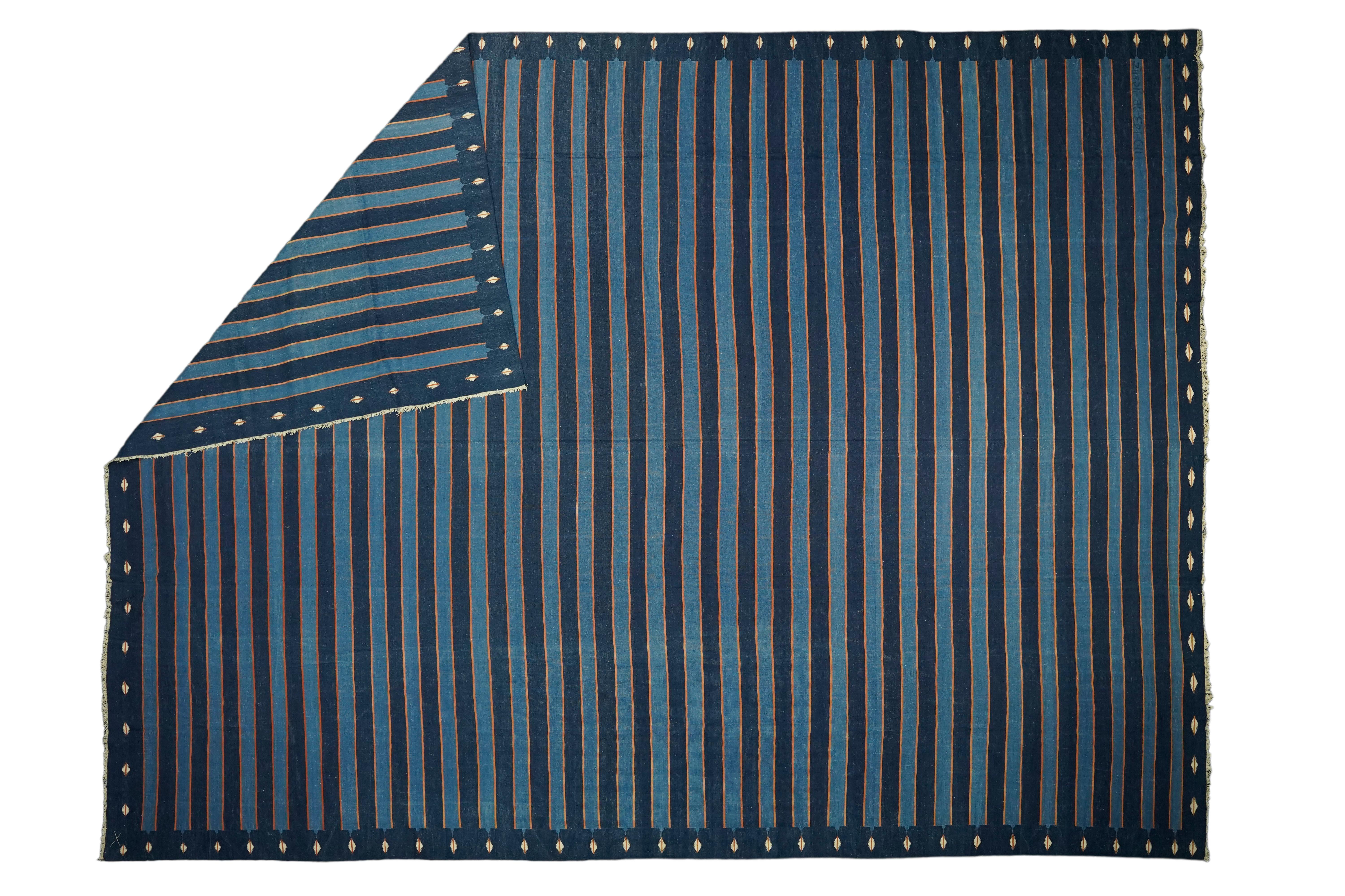 Dieser 13x18 große Teppich ist ein seltener Vintage-Dhurrie-Teppich aus einer aufregenden neuen Kuration von Rug &New Kilim aus der Mitte des Jahrhunderts. Das handgewebte Flachgewebe aus Wolle stammt aus Indien (ca. 1950-1960) und weist blaue