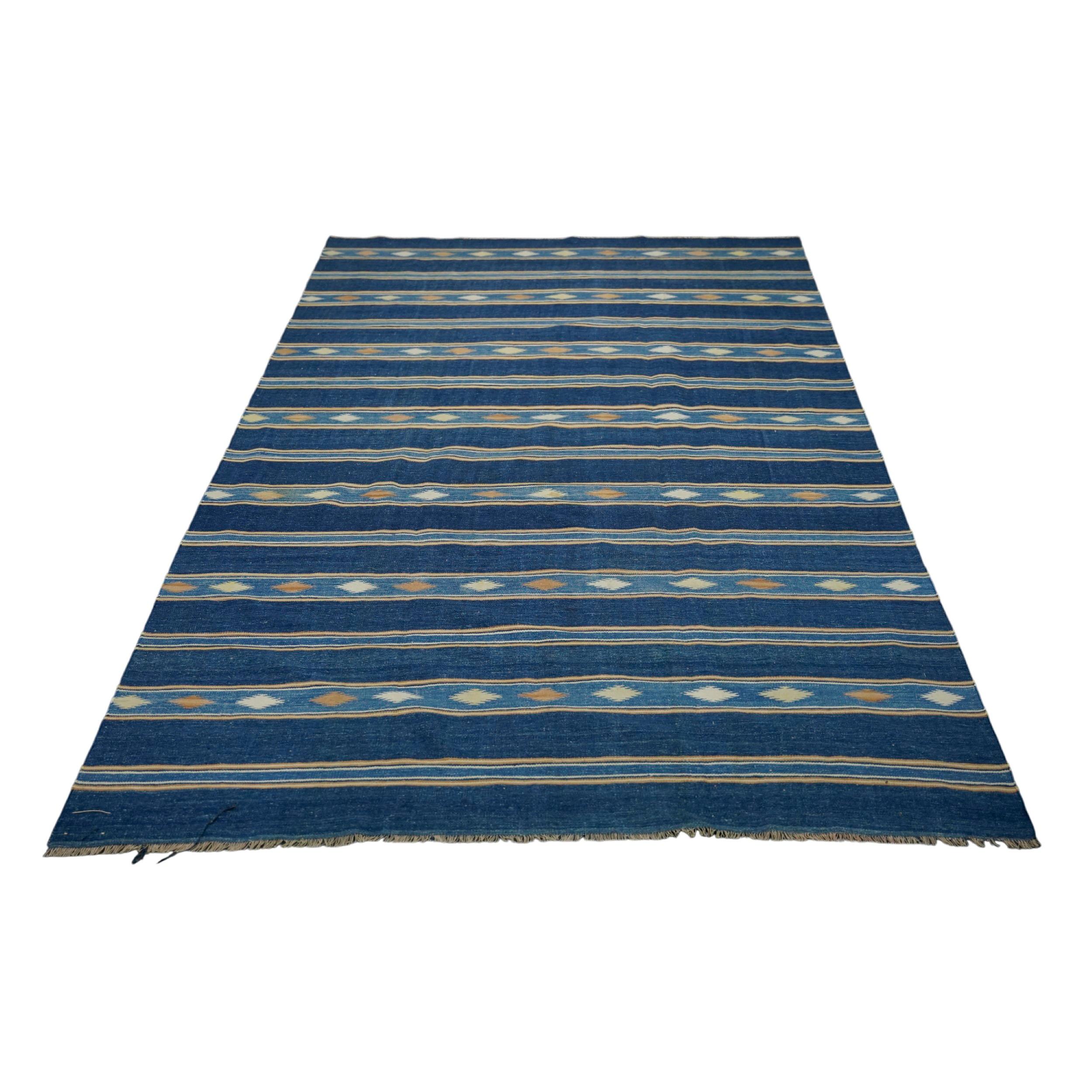 This 5x8 vintage Dhurrie rug is an exciting new curation from Rug & Kilim’s latest acquisition of rare and exemplary mid-century flatweaves of the same style—handwoven in cotton in India circa 1950-1960. 

On the Design: 

Navy blue tones underscore