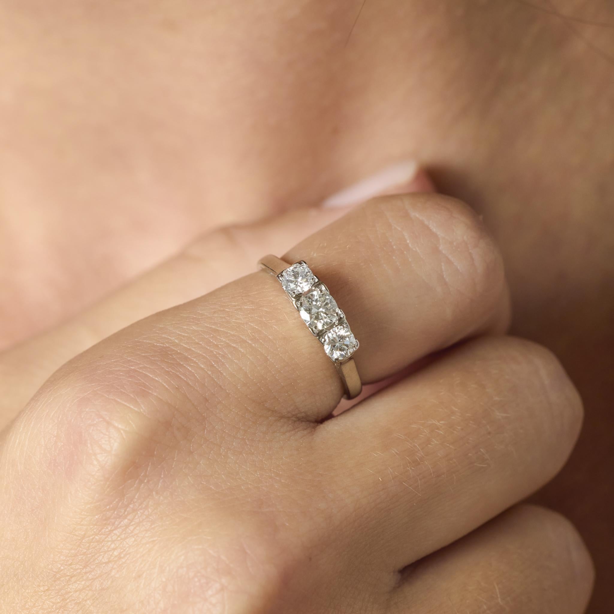 Questo anello vintage in oro bianco 14k presenta tre radiosi diamanti tondi brillanti, che offrono uno scintillio senza tempo e una raffinata semplicità in un design elegante.