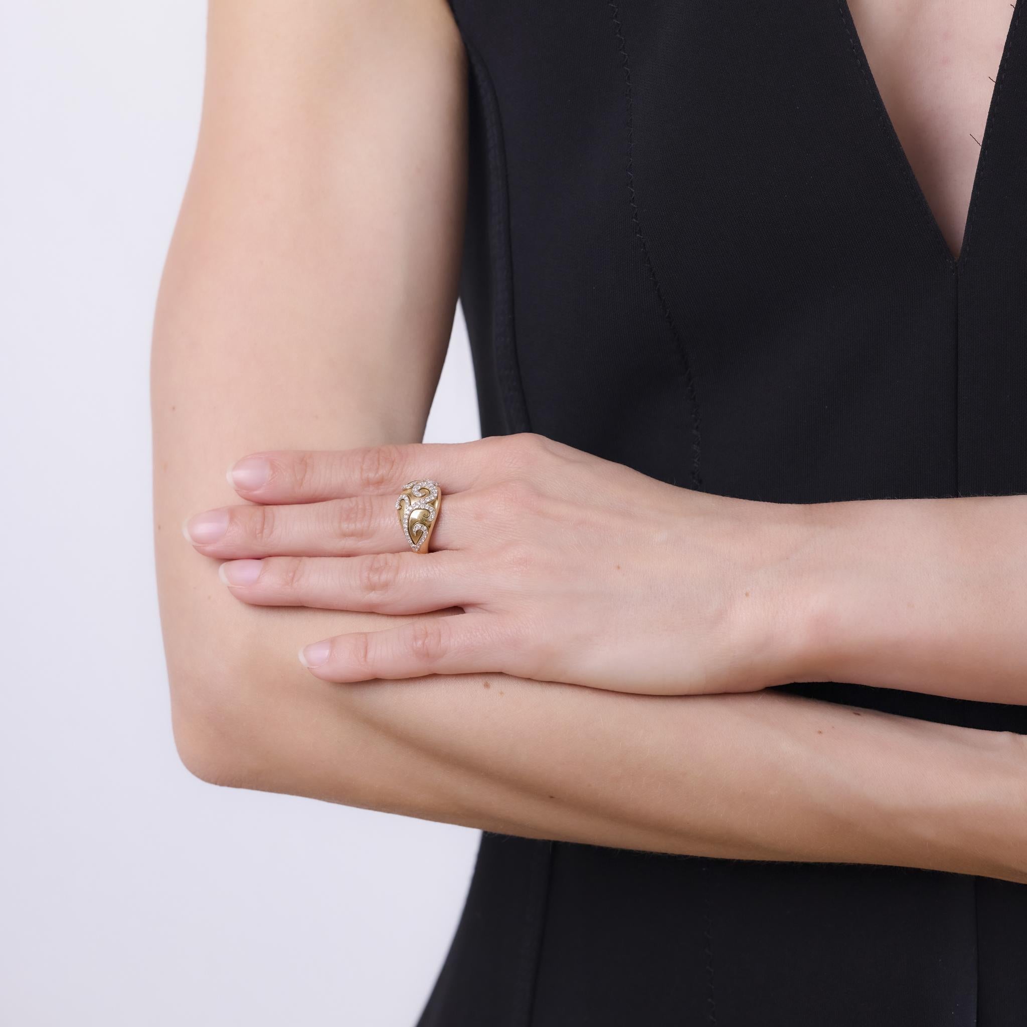 This vintage ring from the 1980s is crafted in 14k yellow gold and features 74 round brilliant cut diamonds totaling approximately 0.60 carats. The diamonds are graded H color and SI clarity, offering lively sparkle across a richly textured gold