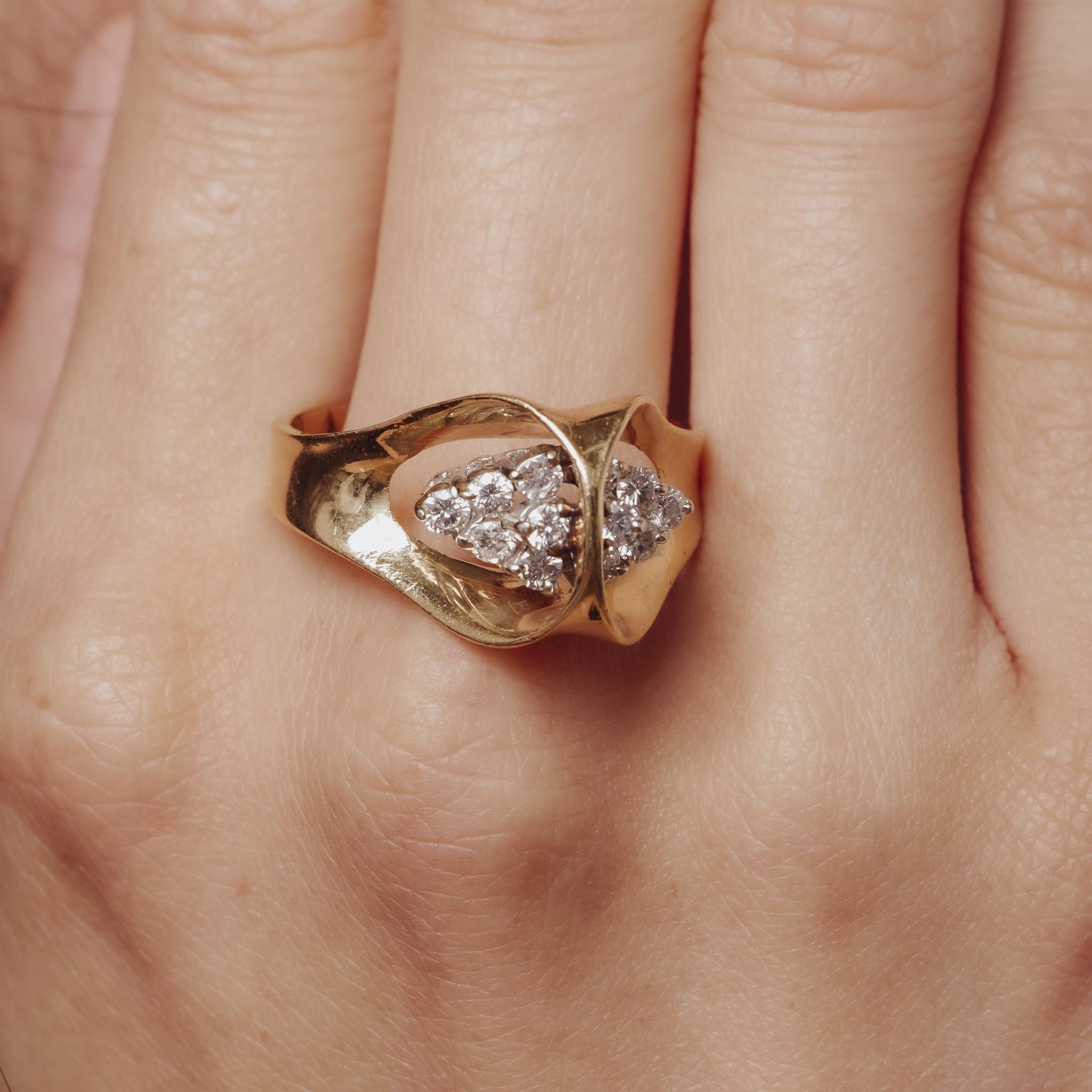 Cette bague vintage des années 1970 en or jaune 14k met en valeur douze diamants ronds brillants, offrant un éclat audacieux mais raffiné qui capture la sophistication classique.