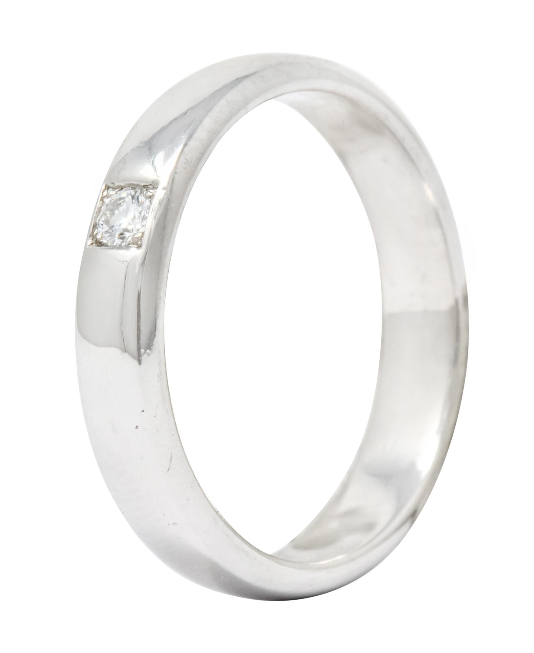 Band style ring centering a square recess bead set with a round brilliant cut diamond weighing approximately 0.07 carat; eye-clean and white

Completed by a high polish

Tested as 18 karat gold

Circa: 1990s

Ring Size: 7 1/2 & sizable

Measures: