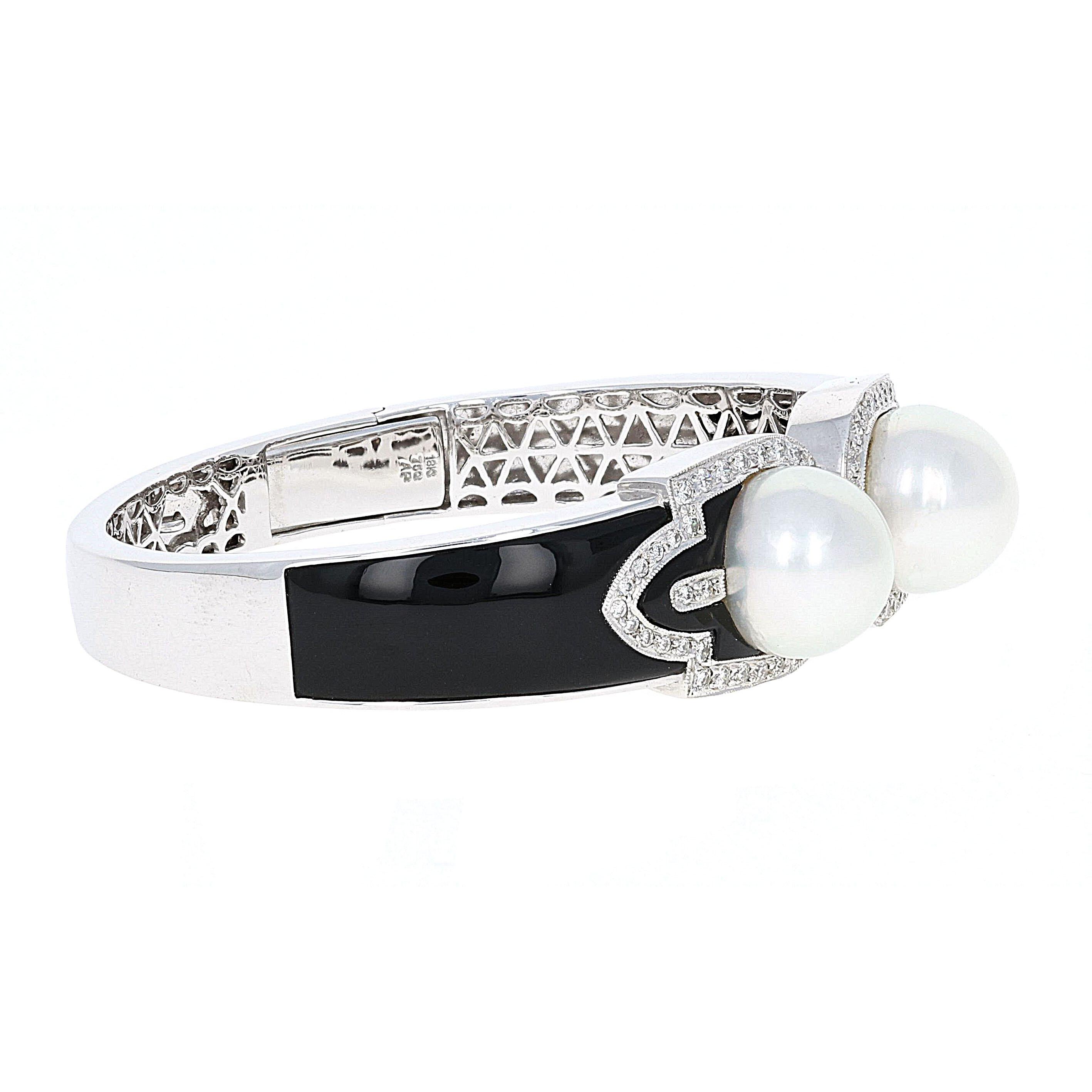 Truly a beautiful piece of jewelry to be enjoyed for years to come. This 1940s inspired bangle bracelet is crafted with 2 large pearls and surrounded by diamonds. The diamonds are very high quality and the onyx is in excellent condition. This is