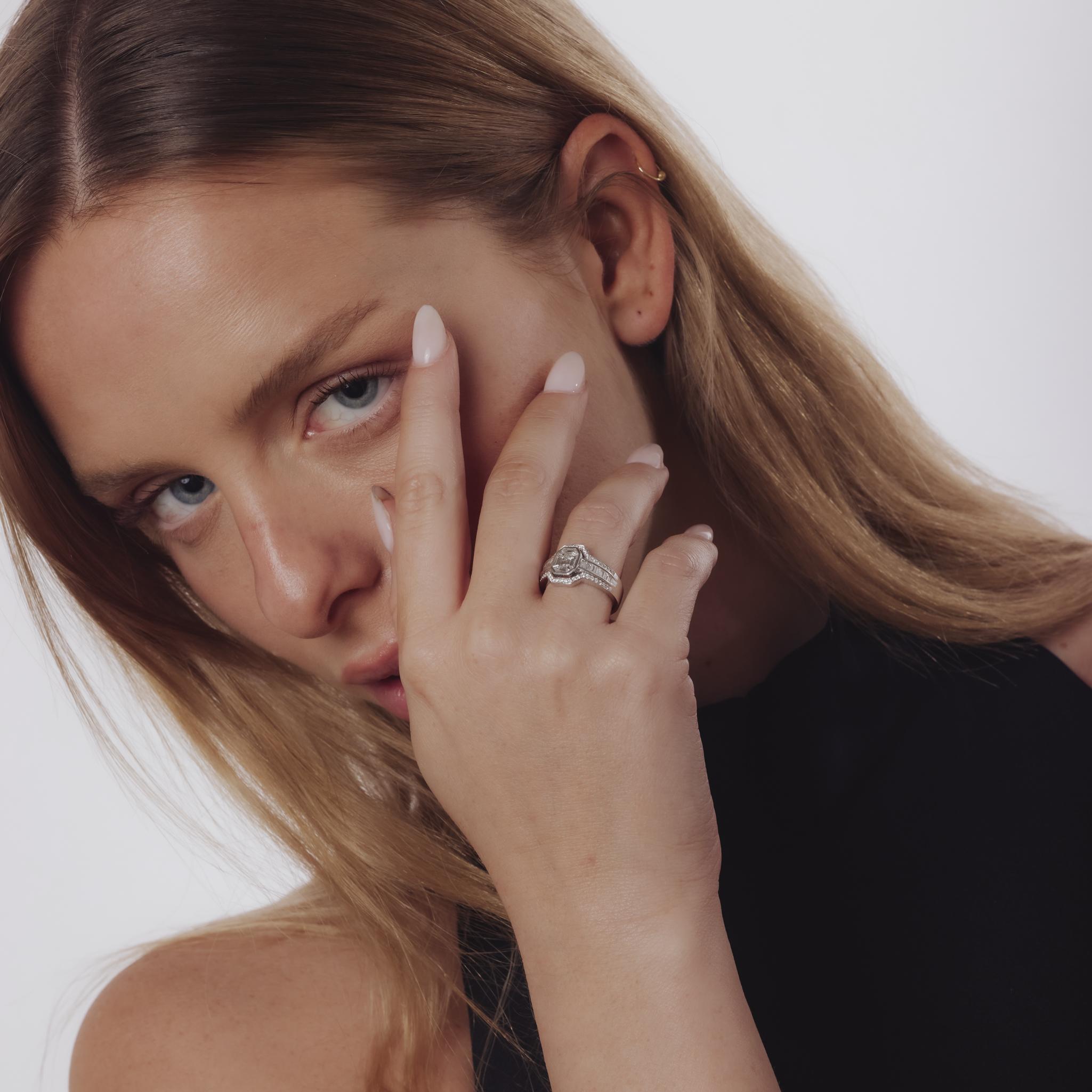 This vintage 1990’s 18k white gold ring showcases emerald and trapezoid cut diamonds framed by baguette and brilliant diamonds for striking elegance and brilliance.