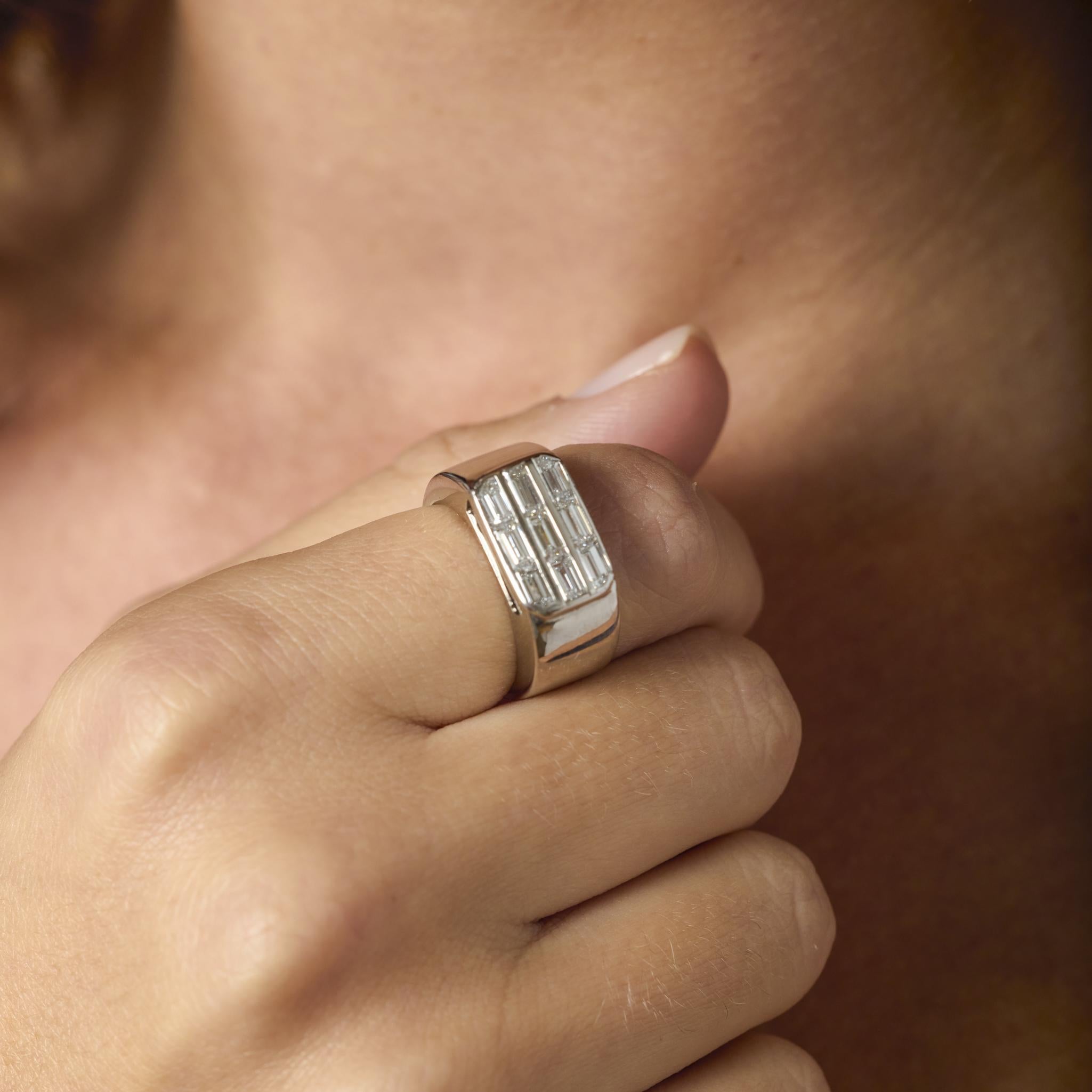 Questo anello vintage in oro bianco 18 carati sfoggia nove diamanti taglio baguette incastonati in un design elegante e moderno che irradia raffinatezza e brillantezza.