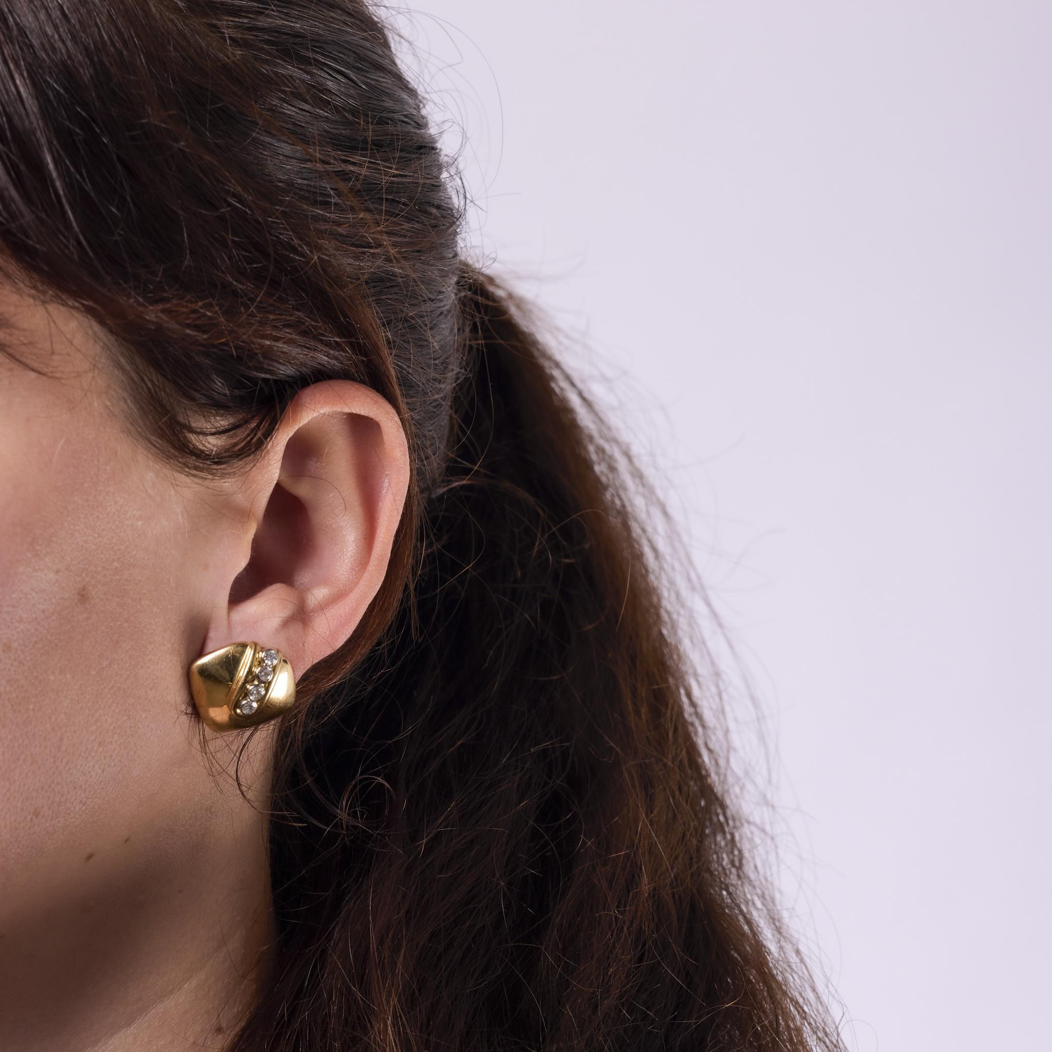 These vintage earrings from the 1980s are crafted in 18k yellow gold and feature eight round brilliant cut diamonds totaling approximately 0.60 carats. The diamonds are graded H color and VS clarity, offering a refined sparkle. Finished with 14k